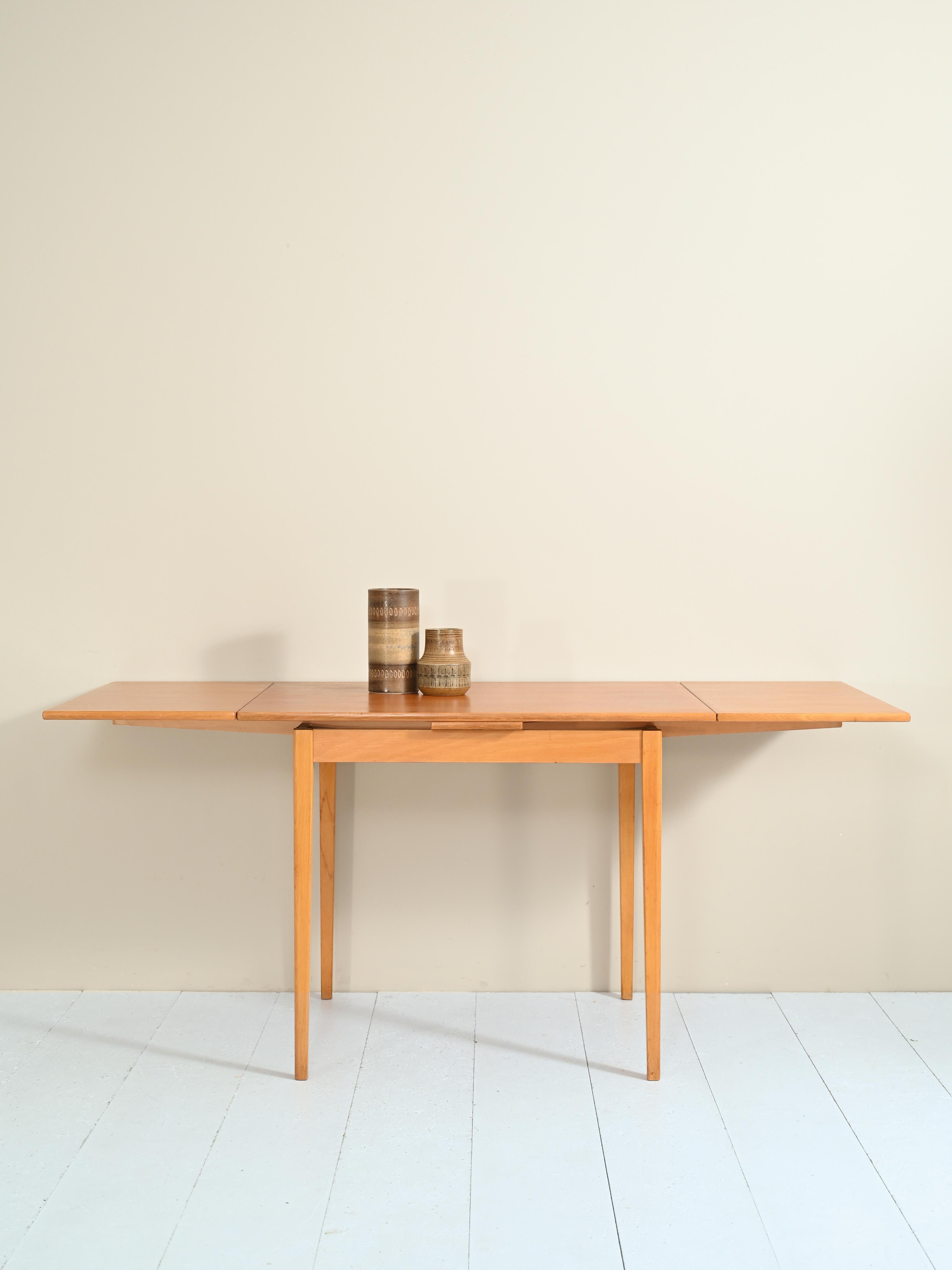 Original 1960s extending table.

Table dimensions closed
W94cm, D65cm, H74cm

Table dimensions open
W70cm, D65cm, H74cm

Formed by a teak top with two pull-out side extensions and an oak frame and legs.
This piece of furniture is versatile
