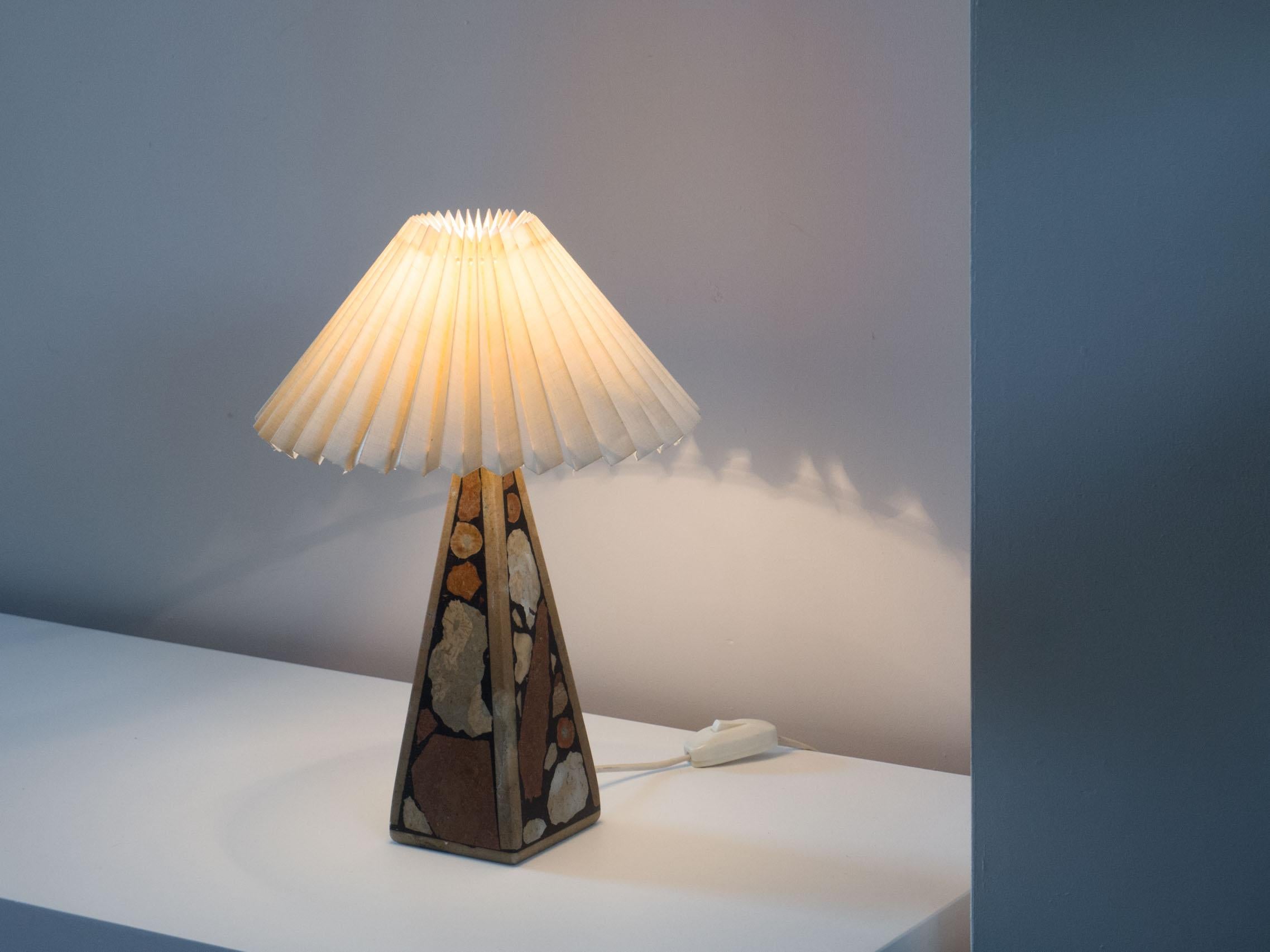 Swedish table lamp sold by Kvarnboden in Lummelunda, Sweden. 1970s.

This table lamp is made from stone and fossils found in the stone from the island of Gotland. It is outfitted with a Le Klint style shade.

The lamp is in excellent condition, the