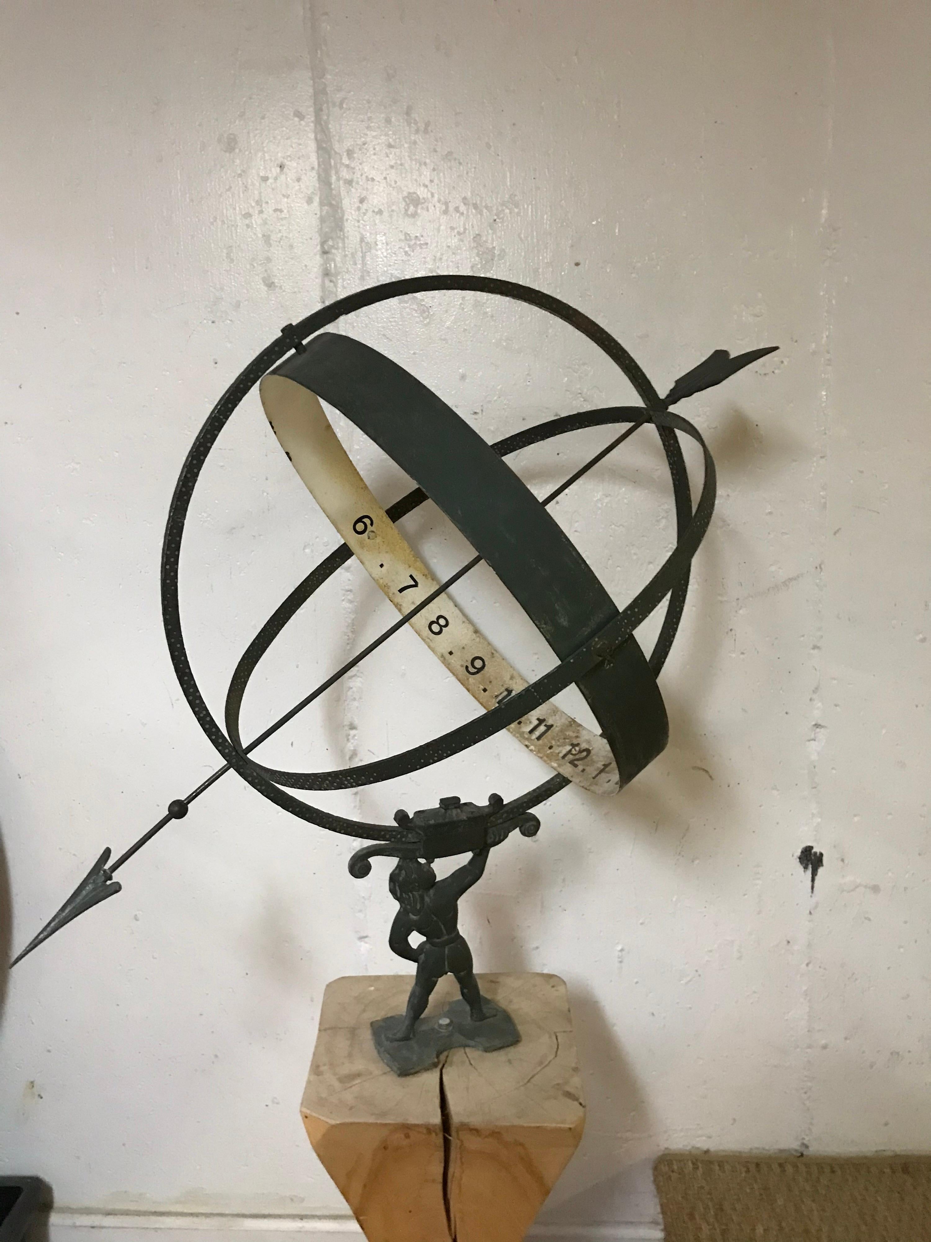 This is a vintage metal Swedish armillary of Atlas mounted on a wood plinth .
The armillary is supported on the arm of Atlas and there is banding with numerals on it . The numbers don't appear to be the originals. The Armillary could be detached