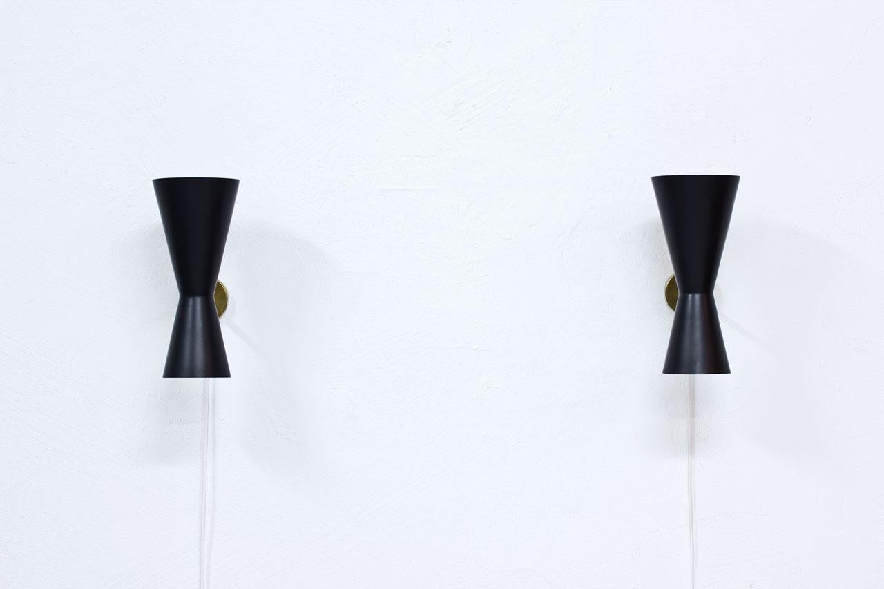 Pair of wall lamps designed by Alf Svensson.
Manufactured by Bergboms in Sweden during the 1950s.
Black lacquered metal reflectors with brass structure.