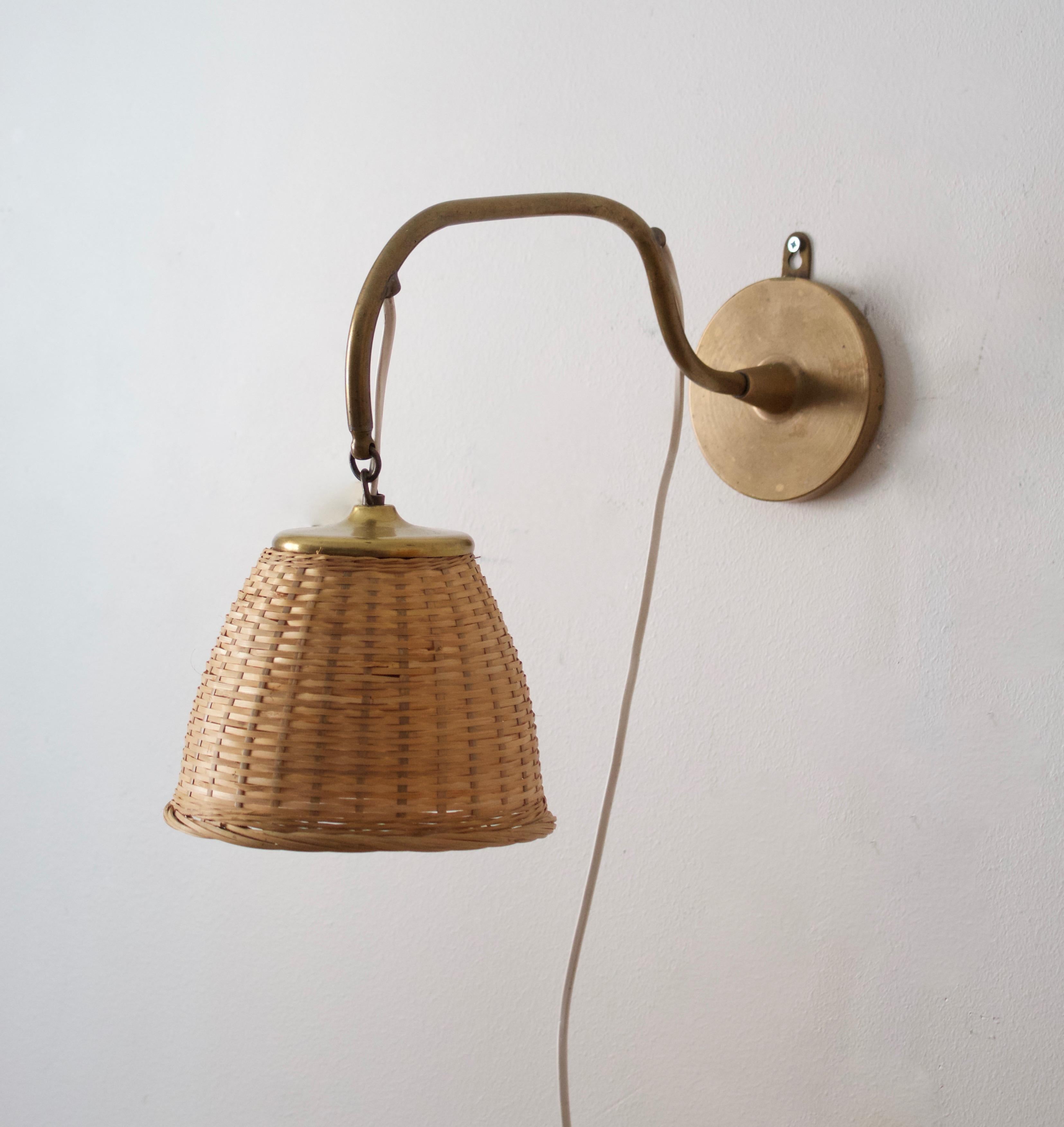 A functionalist wall light / task light, designed and produced in Sweden, 1922. Assorted Vintage rattan lampshade. Engraving to bottom. 

Stated dimensions with lampshade attached as is illustrated in the primary image.