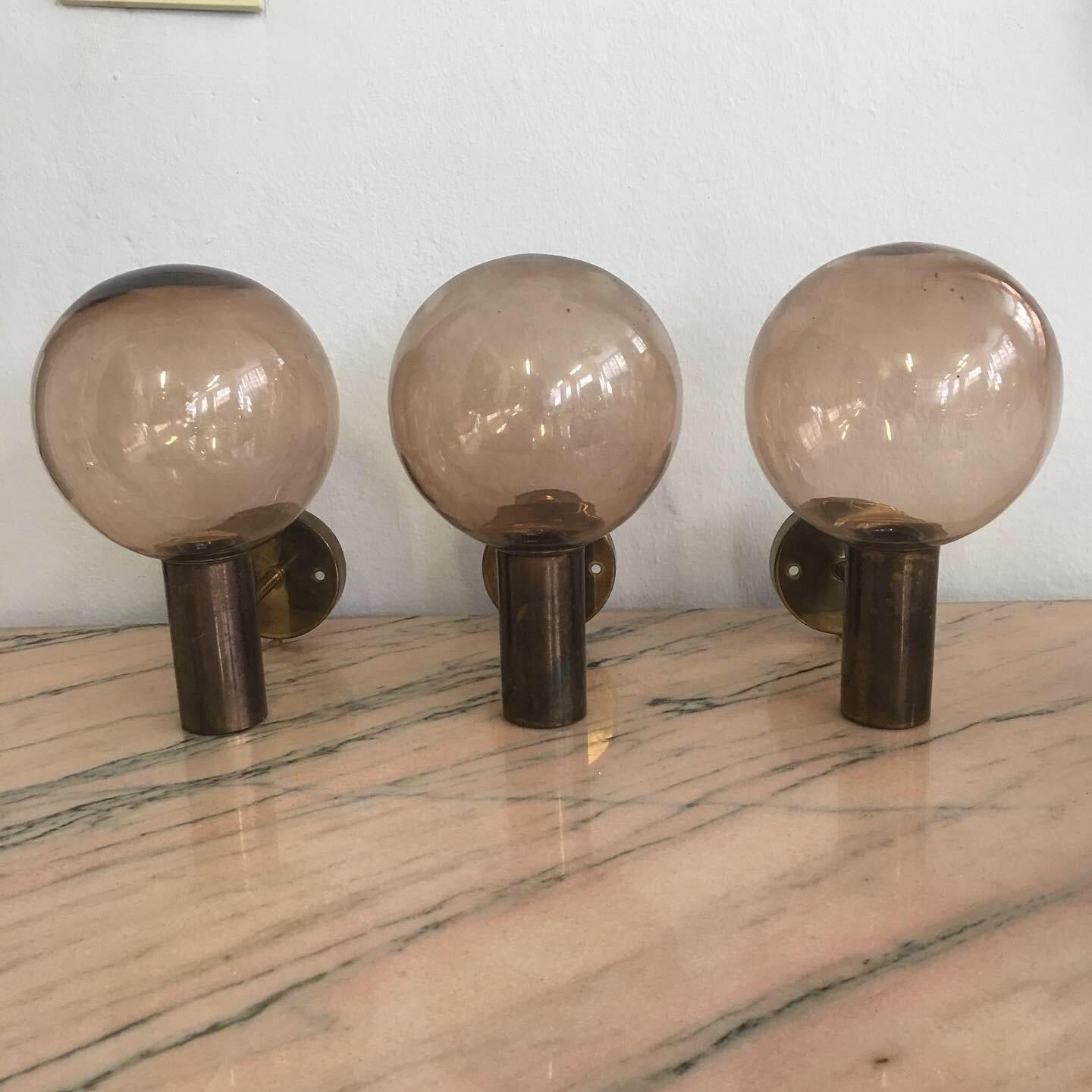 Rare set consisting of three wall lamps, model V-149, with high quality brass frames and fine workmanship holding three fine amber blown glass spheres, designed by Hans-Agne Jakobsson and manufactured by AB Markaryd, from the 1960s.
Each carries the