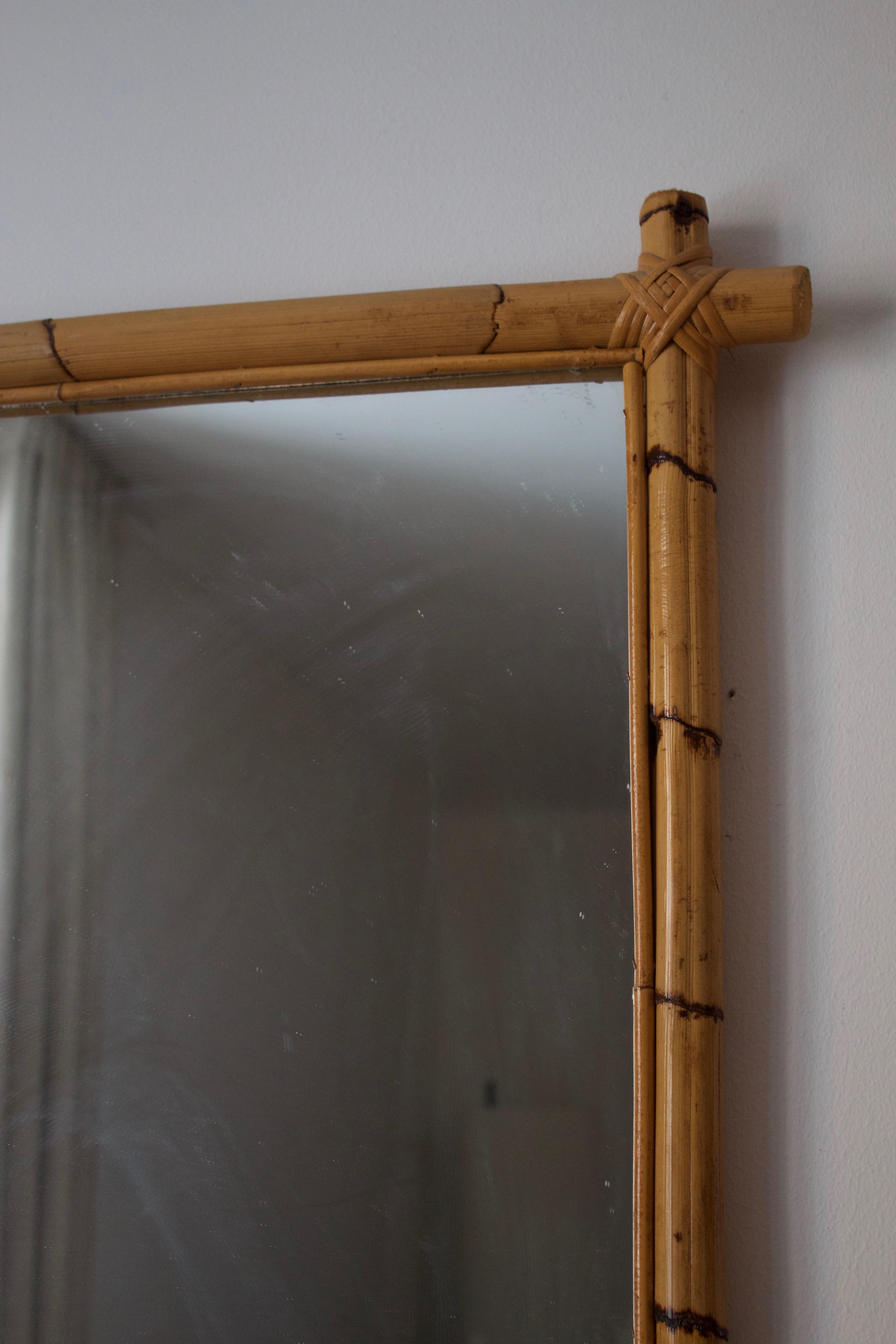 A wall mirror. Designed and produced in Sweden. Executed in bamboo and cane, original mirror glass.