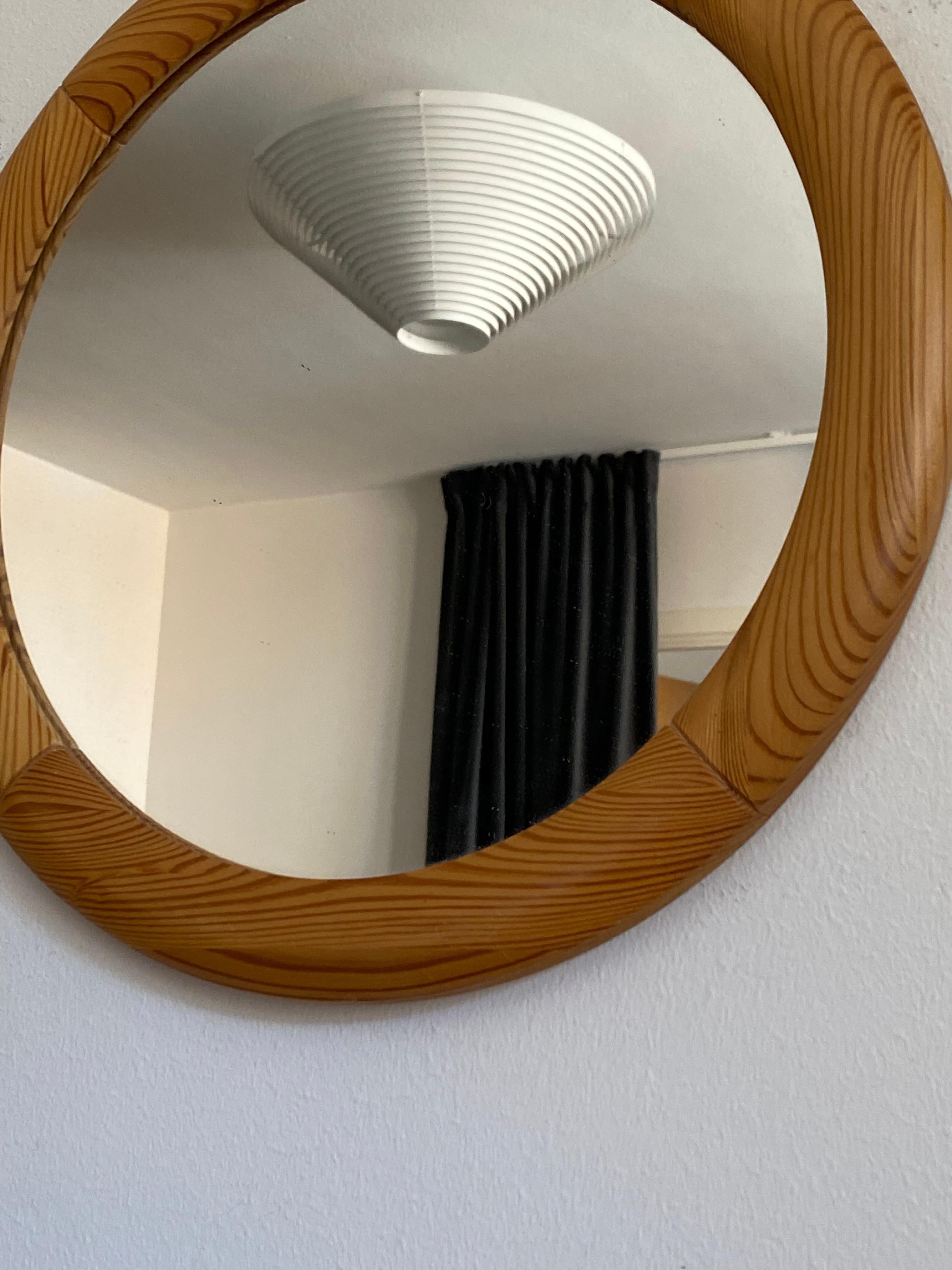 A round wall mirror, frame in solid pine, with it's original mirror glass. Designed and produced in Sweden, 1970s. 

