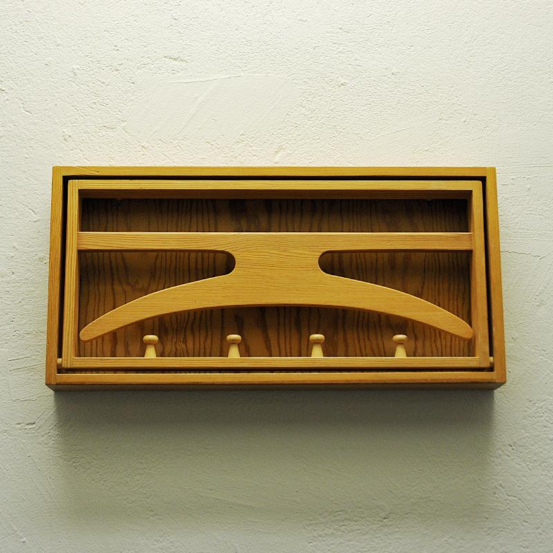 A wall mounted valet/rack of pine wood made in Sweden 1970s. Solid pine rack with clothing hanger included. Four hanging knobs underneath. Perfect for the hallway or bedroom. Nice design. Good vintage condition. 

Measures: 54cmL x 27 cmH x 6.5