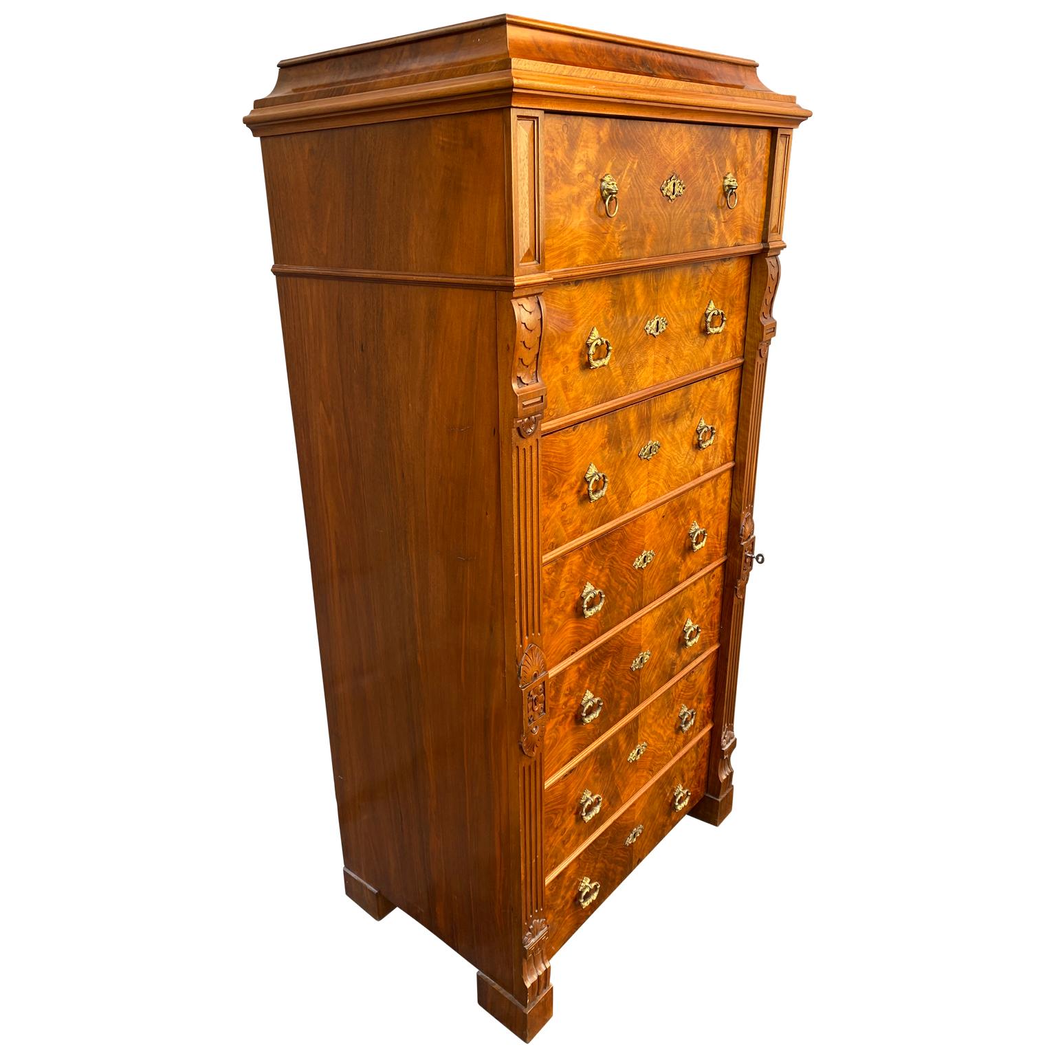 Swedish walnut veneered tallboy chest of 6 drawers with brass hardware.

Top drawer opens to function as small desk. Brass hardware has lion heads.