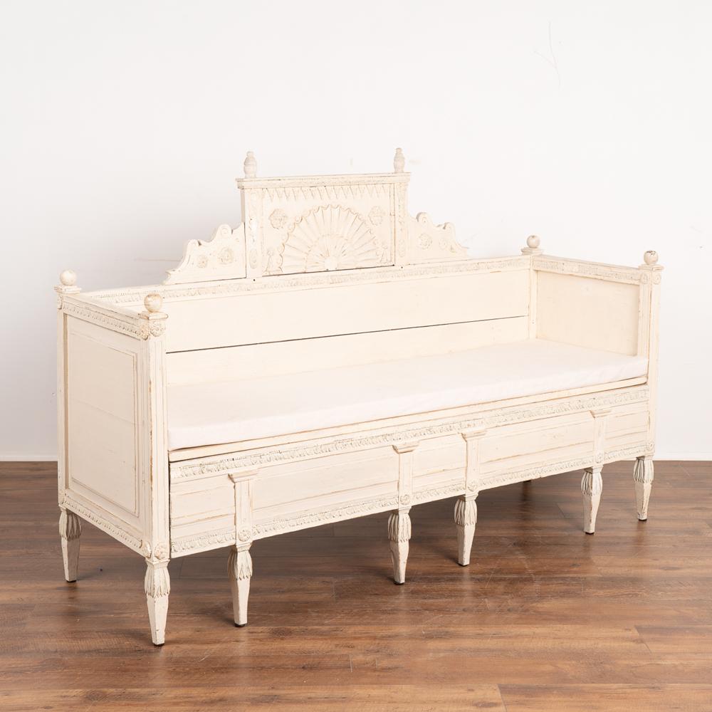 This lovely bench is a wonderful example of Swedish Gustavian craftsmanship with delicately carved faces, leaves, trim and medallions seen best in the close up photos. 
Turned finials and tapered fluted legs add to the timeless appeal and