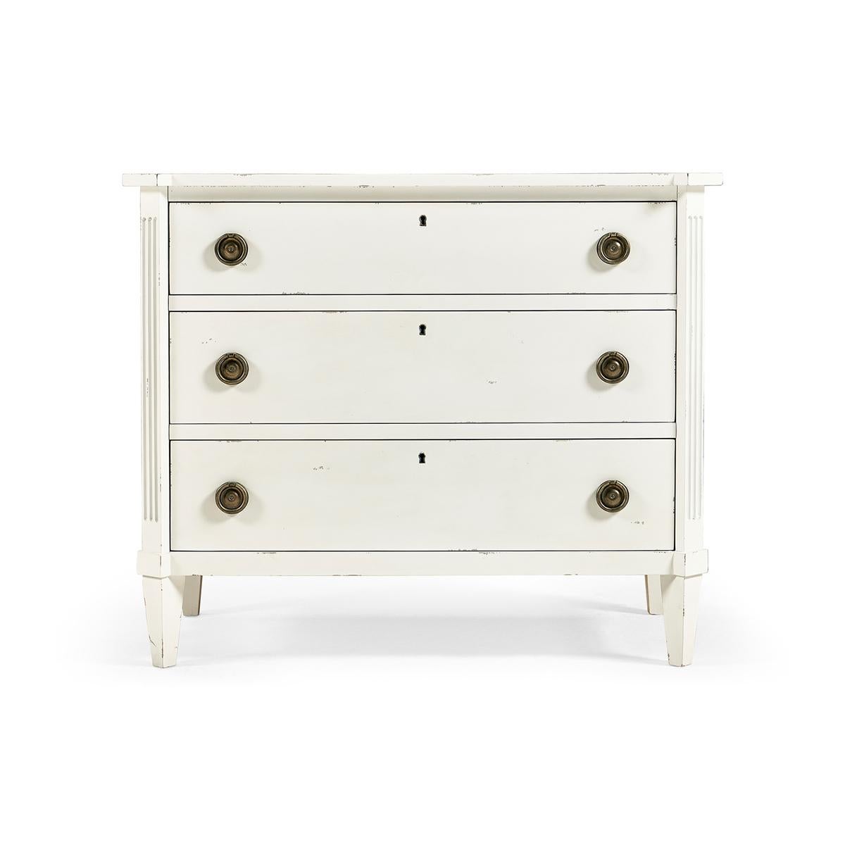 Swedish white painted commode, this neo-classic painted commode with three long lockable drawers, canted corners with fluted stiles, and brass ring pull handles on square tapered legs. 

Dimensions: 38