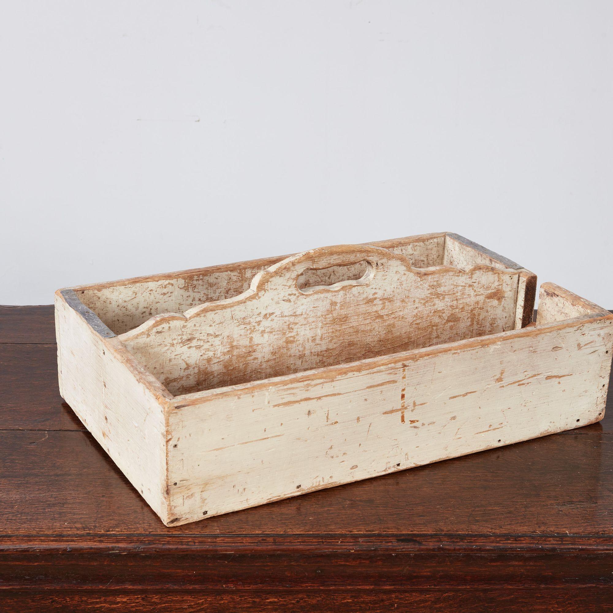 A 19th century Swedish wooden cutlery tray with a curved slotted central handle and divider between two compartments, one with a notch for long utensils.  Retains old painted finish.  