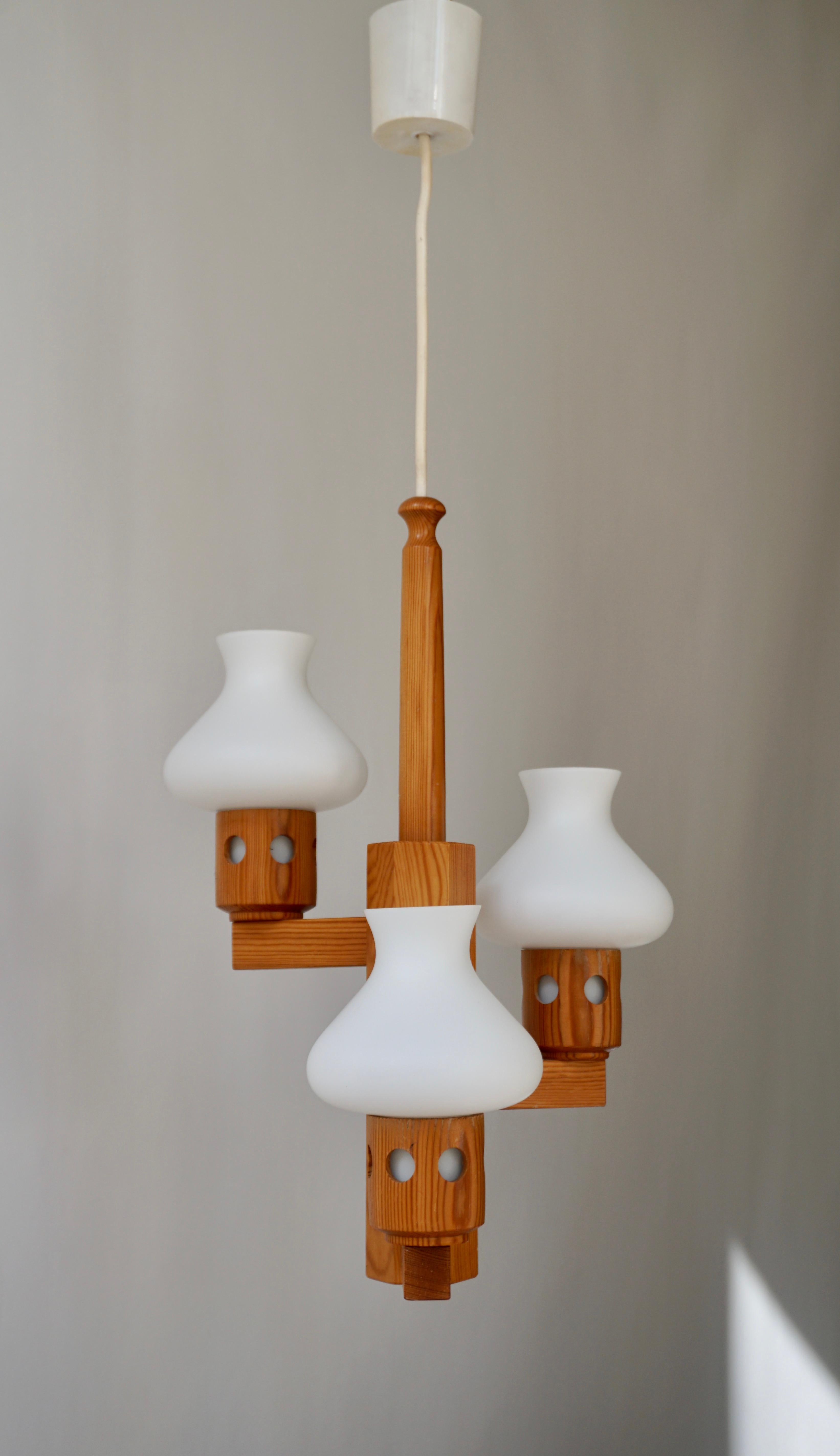 Chandelier, pine wood and opaline white glass, Sweden, 1950s -1960s - 1970s. 

This large sculptural wooden chandelier with three white spheres create a warm and soft environment. The wood is solid and the shades reflects the light perfect which