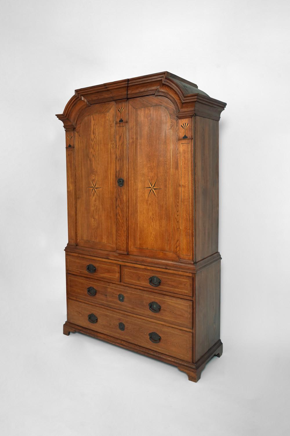 Natural wood cabinet opening with two doors in the upper part and four drawers in the lower part, decorated with light and dark wood marquetry of wind roses and framed with nets. Arched molded cornice. Handles and keyholes in hammered bronze. Label