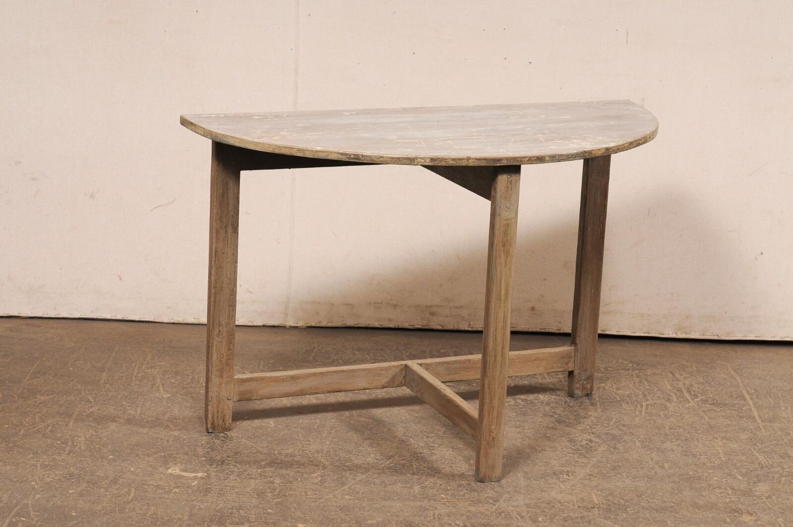A Swedish wooden demi-lune table from the early 20th century. This antique console from Sweden features a semi-circular (or half-moon) shaped top, which is raised upon three straight and squared legs, giving the table a very clean and minimalist