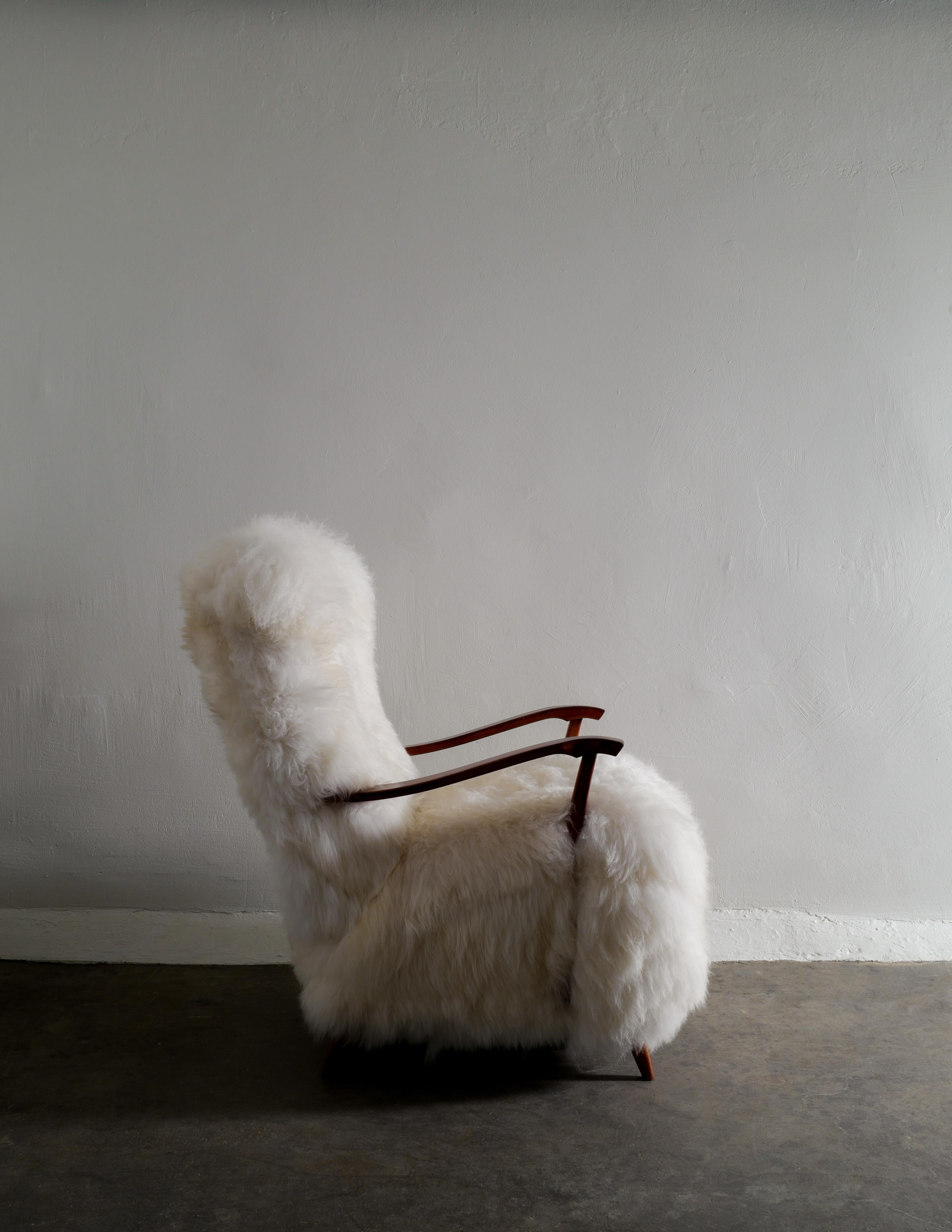 Rare Swedish armchair in lacquered beech with white long hair sheepskin produced in Sweden in the 1960s. In good vintage condition and fully restored and upholstered by our professional. 

Dimensions: H: 99 cm W: 74 cm D: 96 cm SH: 47 cm.