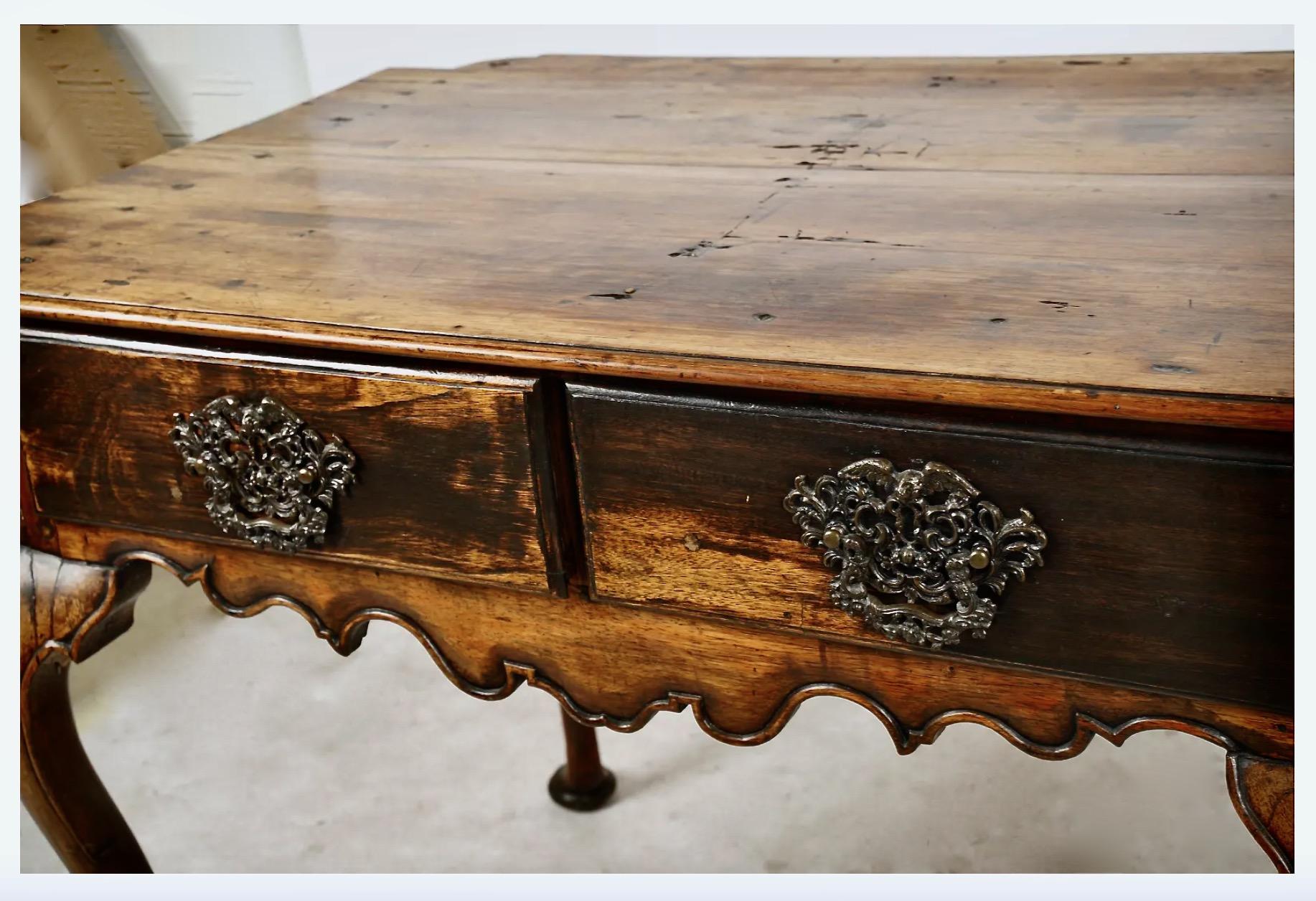 Beautiful 18th century Swedish Rococo two-drawer writing or side table with a finely carved shaped skirt and cabriole legs. The unusual form of the top makes this table a true eye-catcher. Originally ebanized, the table now displays an old waxed and