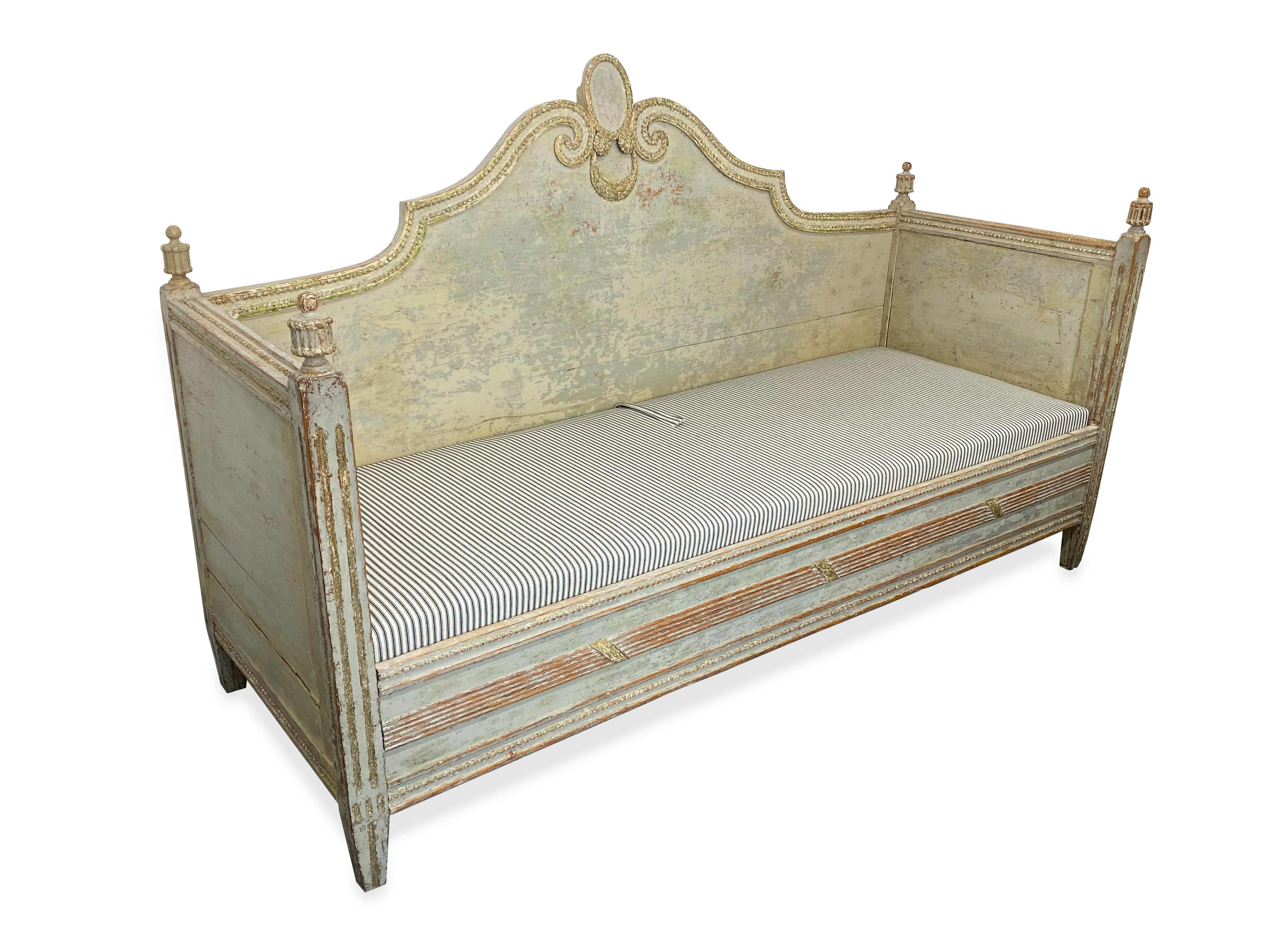 Elegant handcarved Sweedish Gustavian daybed / settee with gilted wood decor along the top edge of the backrest. . An exceptionally rare example of Gustavian workmanship. Circa 1790s. Included with this piece, two upholstered seat cushions that