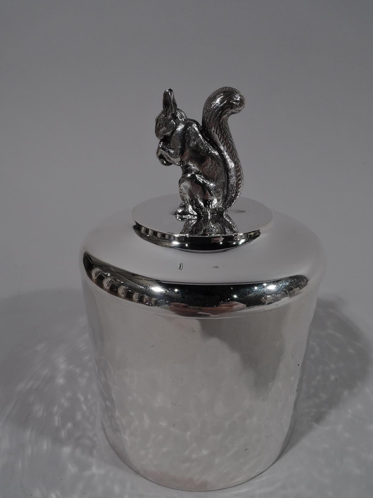 Sweet silver box with squirrel finial. Drum form with soft and shimmering hand hammering. Compatible domed cover with cast nut-nibbler hunched over his find, which he grips with tensile forepaws. Box underside marked “Sterling” with stamp for Marie