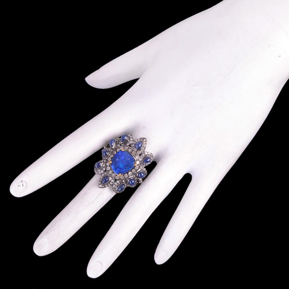 Sweet and bright floral design opal ring with diamonds set in silver and 18K Gold is sassy and sits very nicely on your finger.
 
Ring Size: 7 ( Can be sized )

18kt gold:2.07gms
Diamond:1.23cts
Silver:5.19gms
Blue Sapphire: 2.45cts
Opal Doublet: