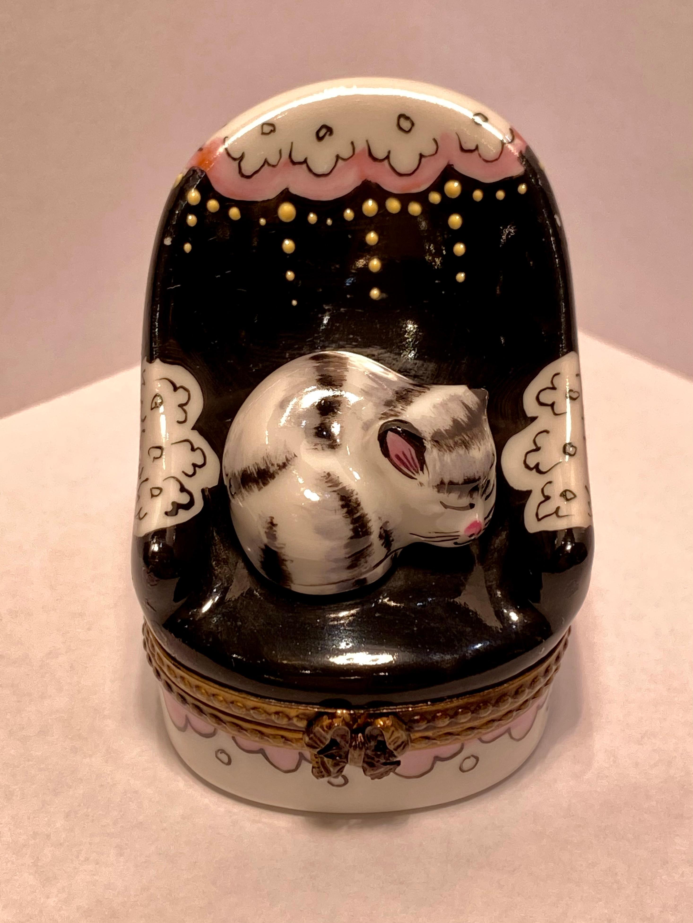 Beautiful Limoges porcelain chair shaped trinket box features an adorable black and white sleeping cat snuggled up on the chair's seat. The chair is handmade and hand painted in France and has a bold black field with pretty scalloping pink accents