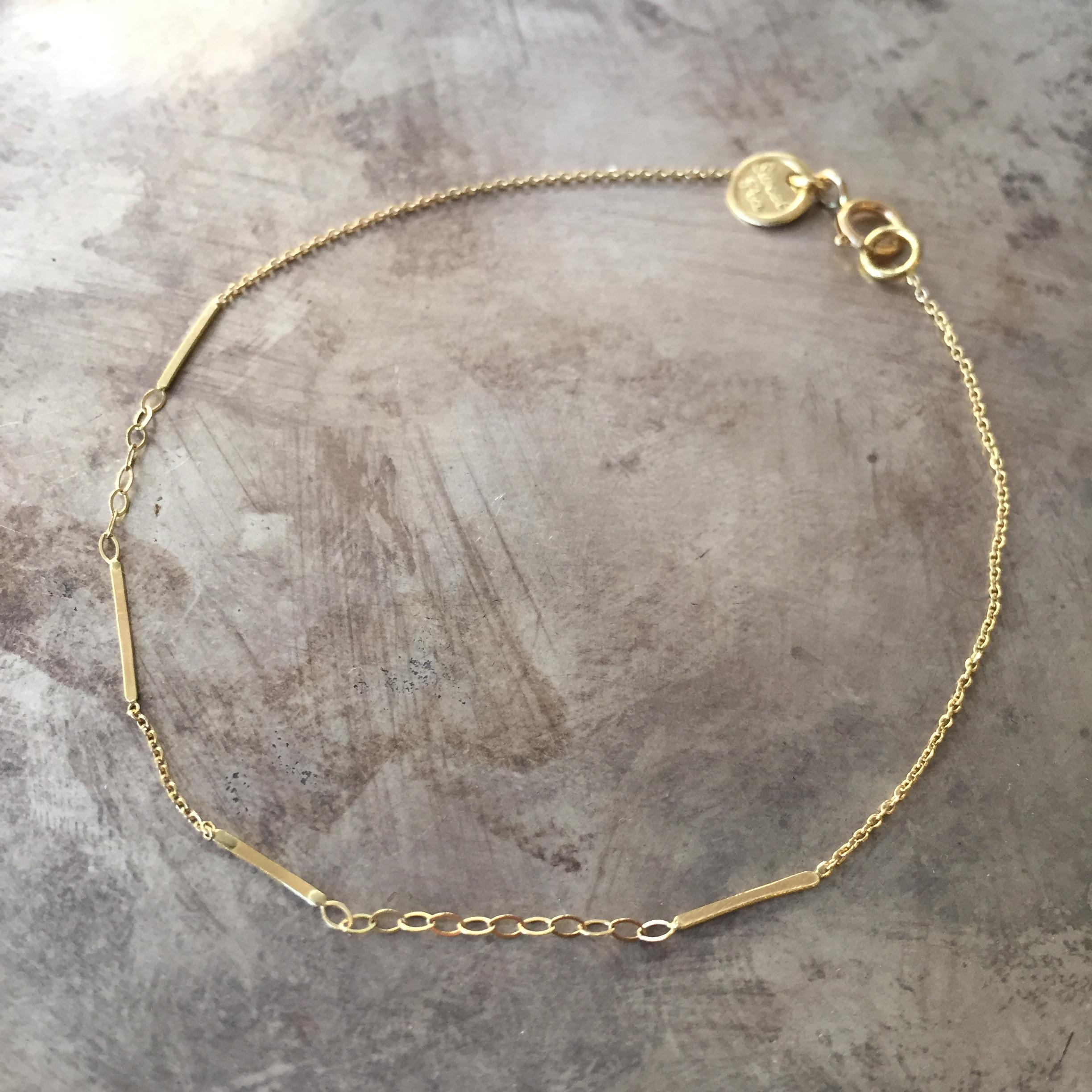 This bracelet is made from 18k yellow gold with sections of fine diamond cut chain and oval link chain with scattered organic bar details. This bracelet is 17.5cm long but can be made to order in any required length; please contact us for further