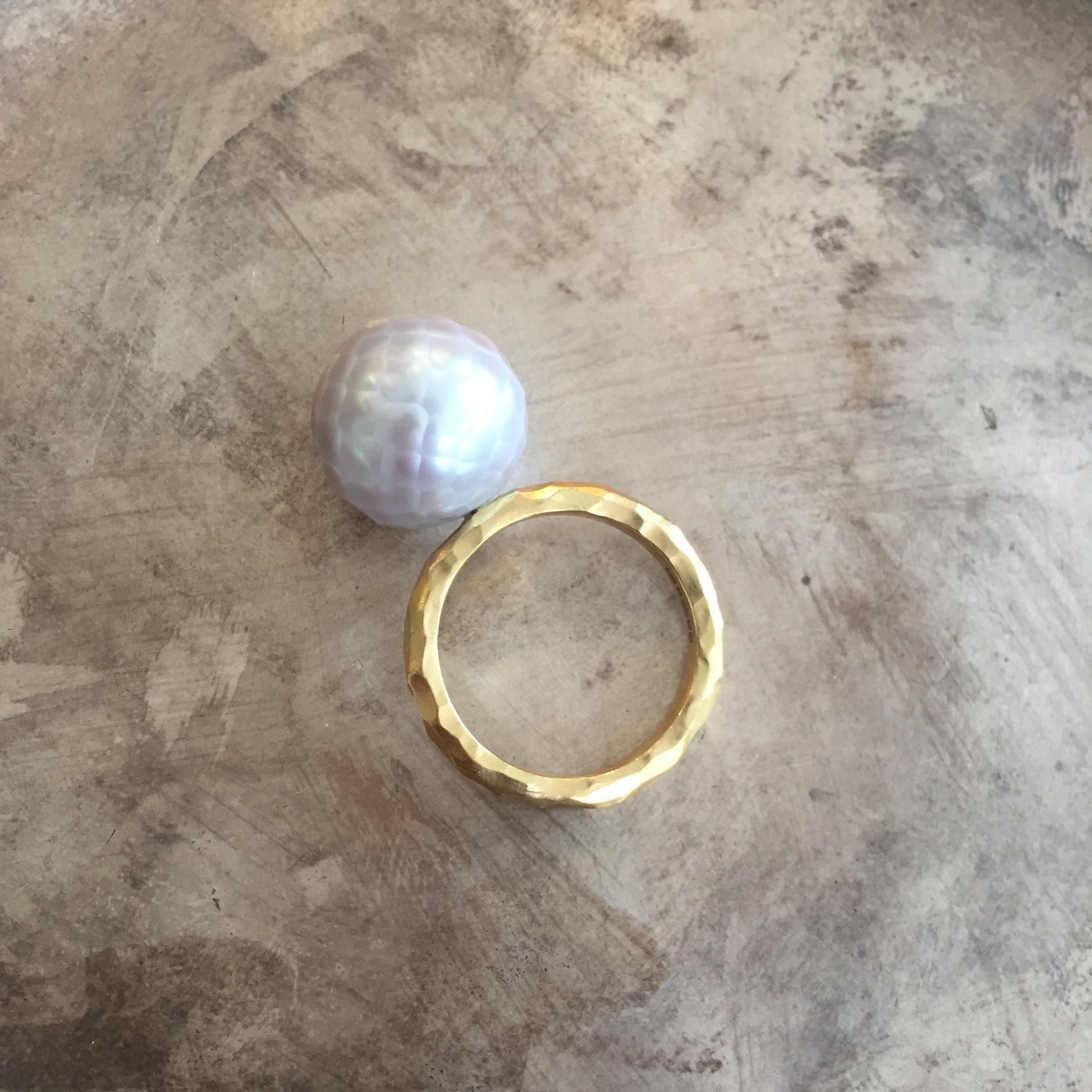 This stunning ring from Sweet Pea features an 18k yellow gold hammered 2.5mm wide band with a brushed finish. The unique faceted pearl is 13mm in diameter and is a soft pink-grey colour. This one-off ring is a UK size L 1/2.