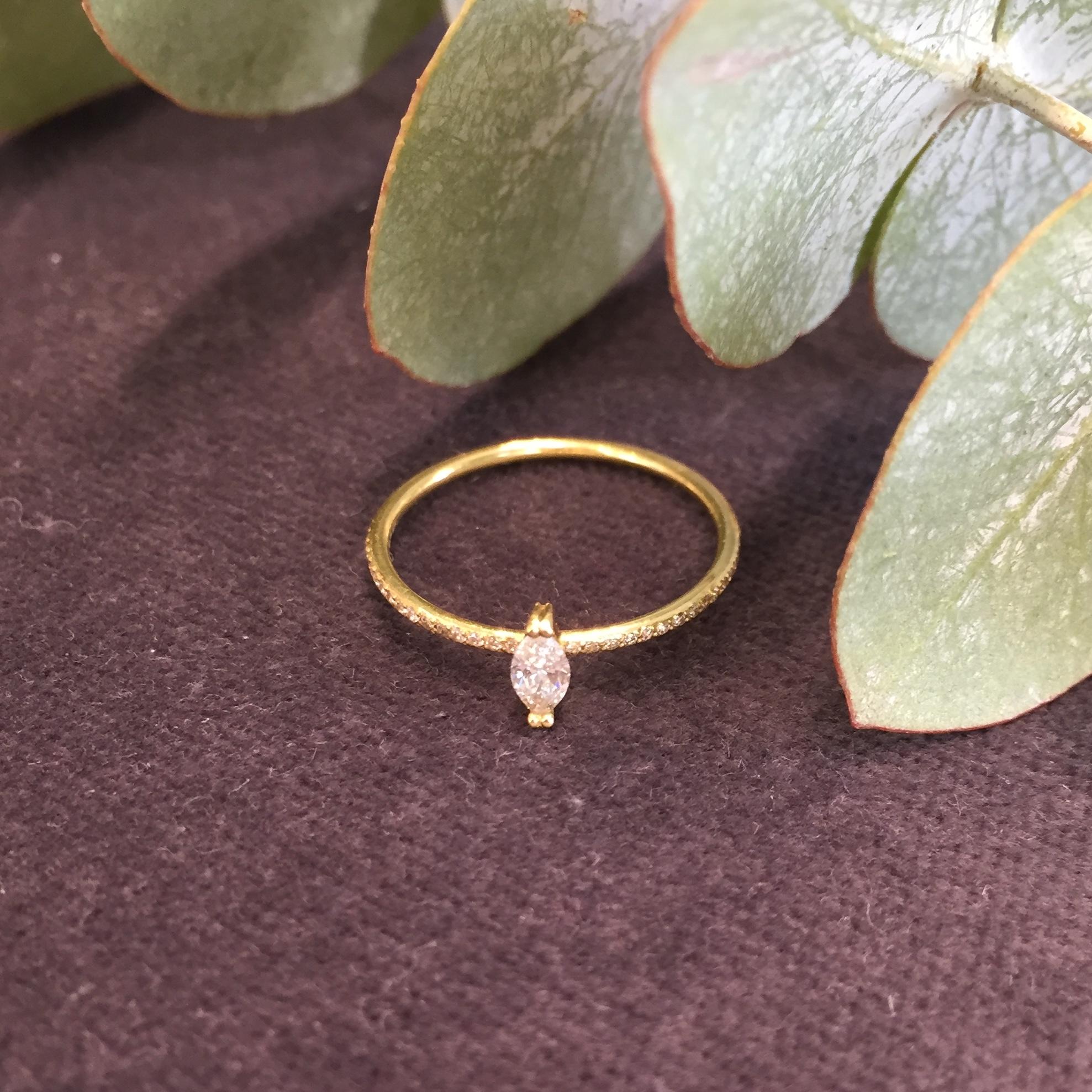 This is a timeless classic engagement ring made from 18k yellow gold. The delicately claw set 0.12carat marquise white diamond sits perfectly on a 1.2mm pave set white diamond eternity band. This piece is a UK ring size L, due to the fully diamond