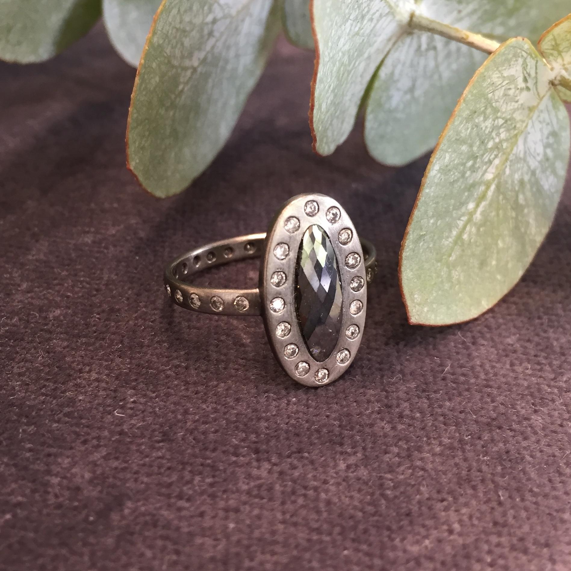 This 18ct white gold and black diamond ring is a one-off piece made by hand in our London workshop. The faceted black oval shaped diamond is 1.15carats (approximately 11.57mm x 4.10mm) and sits in a surround of 16 brilliant cut salt and pepper