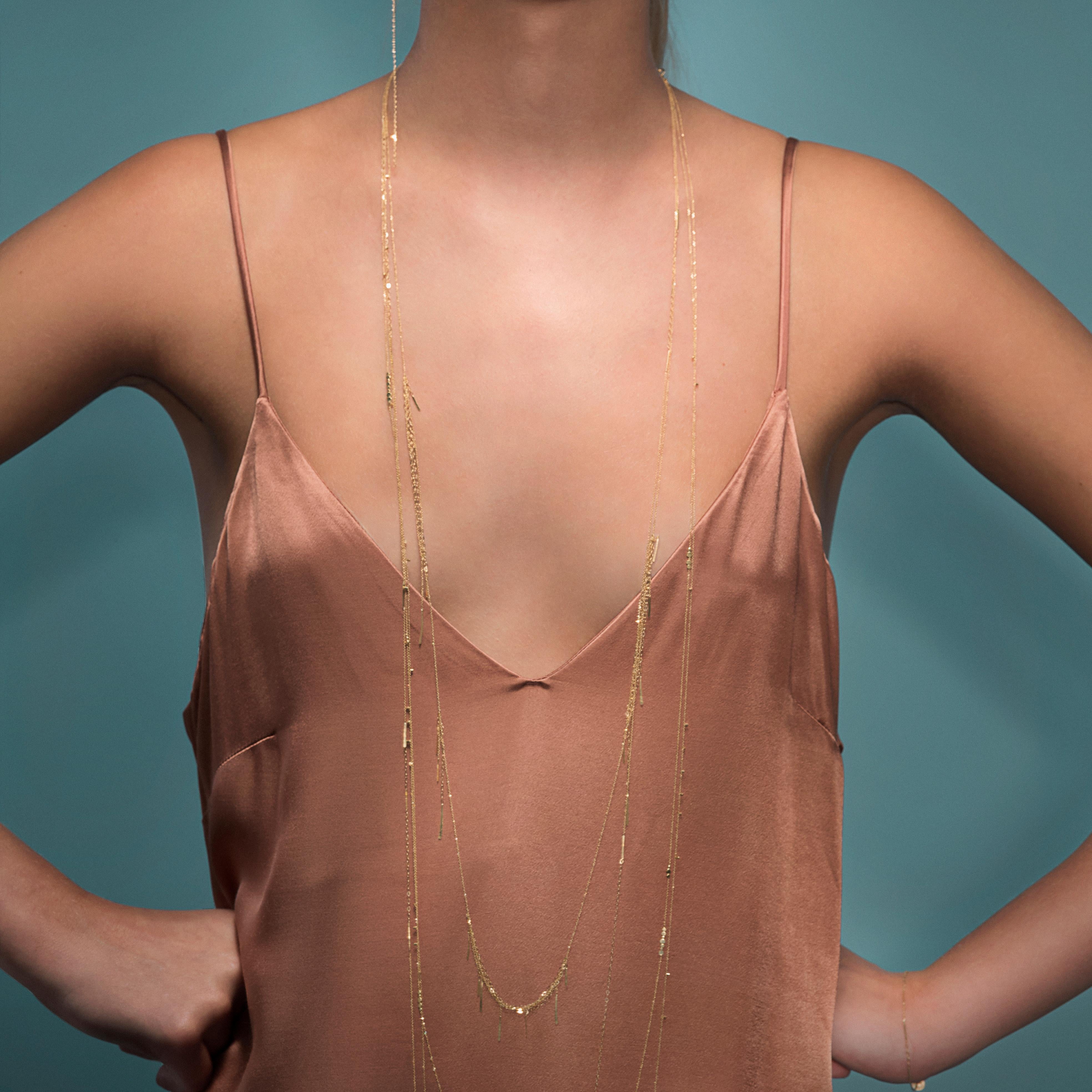 This stunning 101cm long necklace made from a mix of 18kt yellow gold fine chains features sections of layered chain and hanging bar details that catch the light beautifully. It can be worn as a long necklace or wrapped around to give a layered