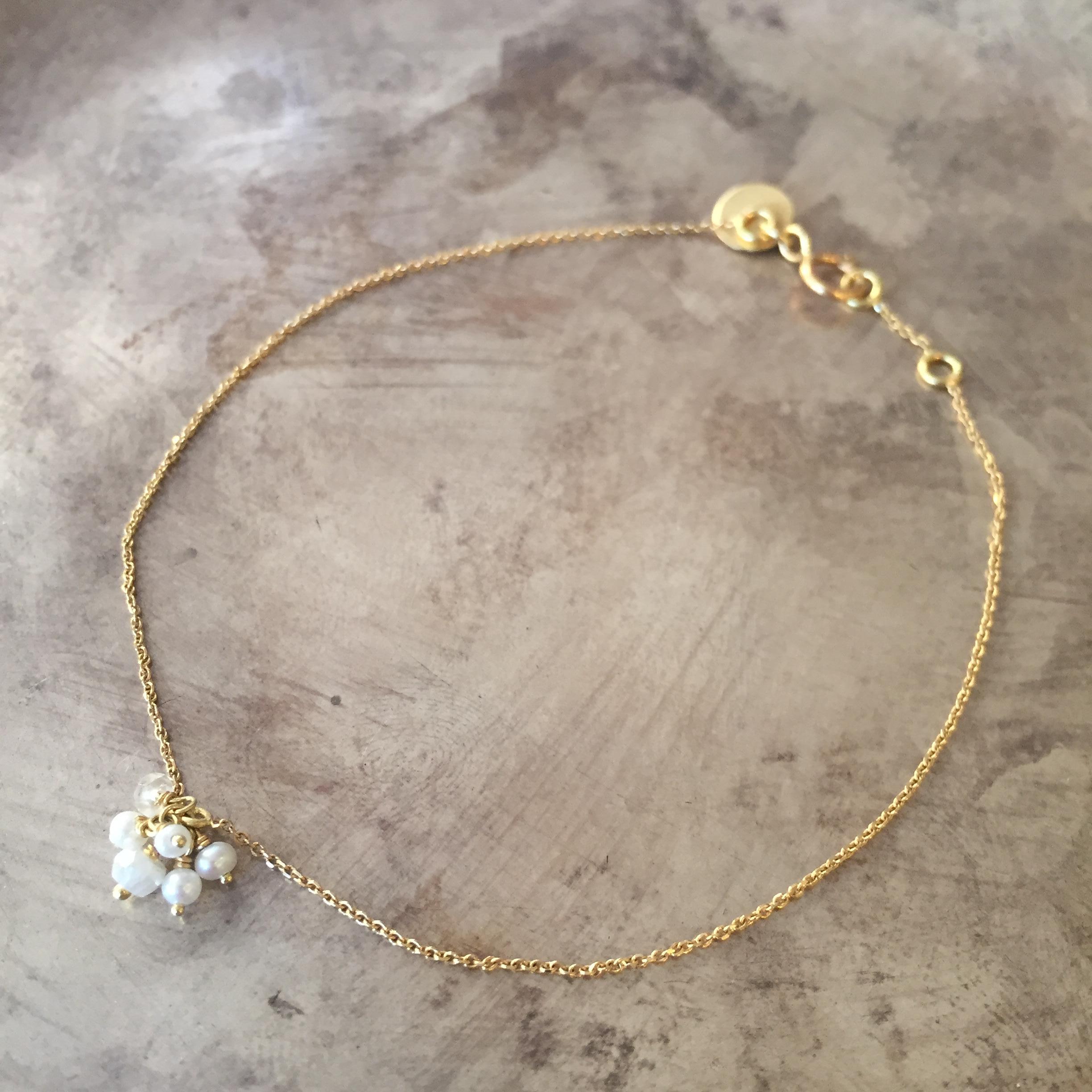 This 18k yellow gold fine chain bracelet has a single cluster of seed pearls and moonstone beads creating a dainty yet eye-catching piece! Made from diamond cut fine 18k chain this bracelet is the perfect addition to anyone's wrist. The total length
