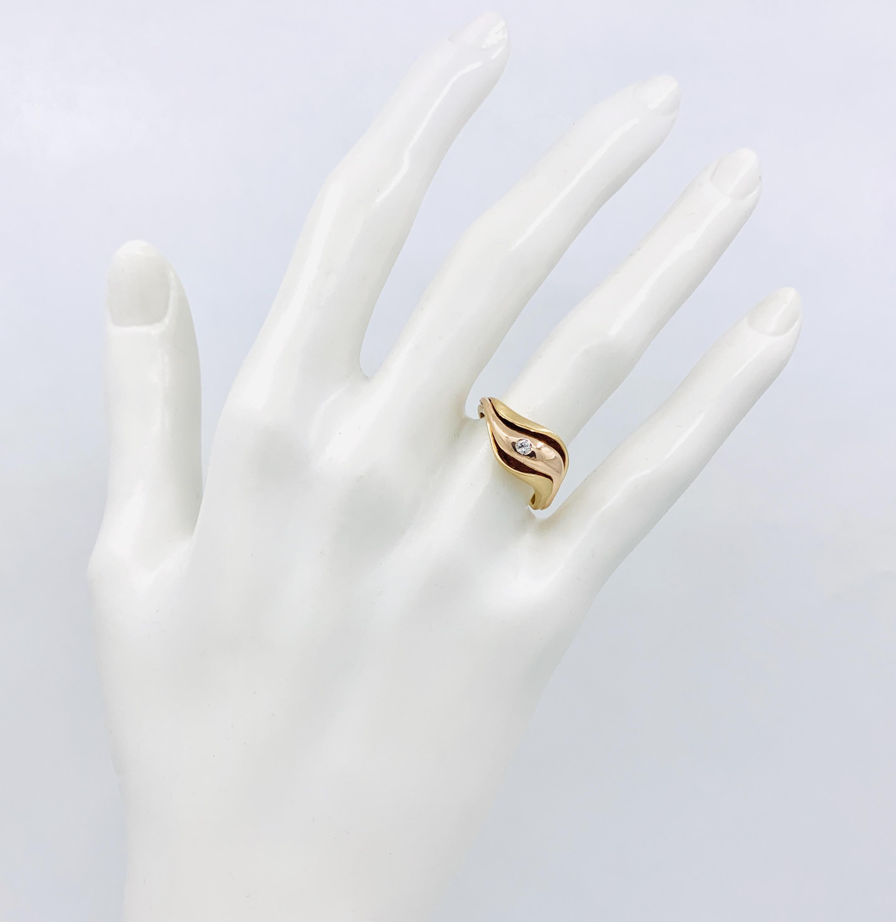Dieser wunderschöne und sexy Ring von Eytan Brandes ist ein frei geformter Schlenker aus satiniertem, gebürstetem Gelbgold, der sich vorne anmutig öffnet und eine polierte Ranke aus Roségold enthüllt.  Ein 0,06-Karat-Diamant in Hammerschlagfassung
