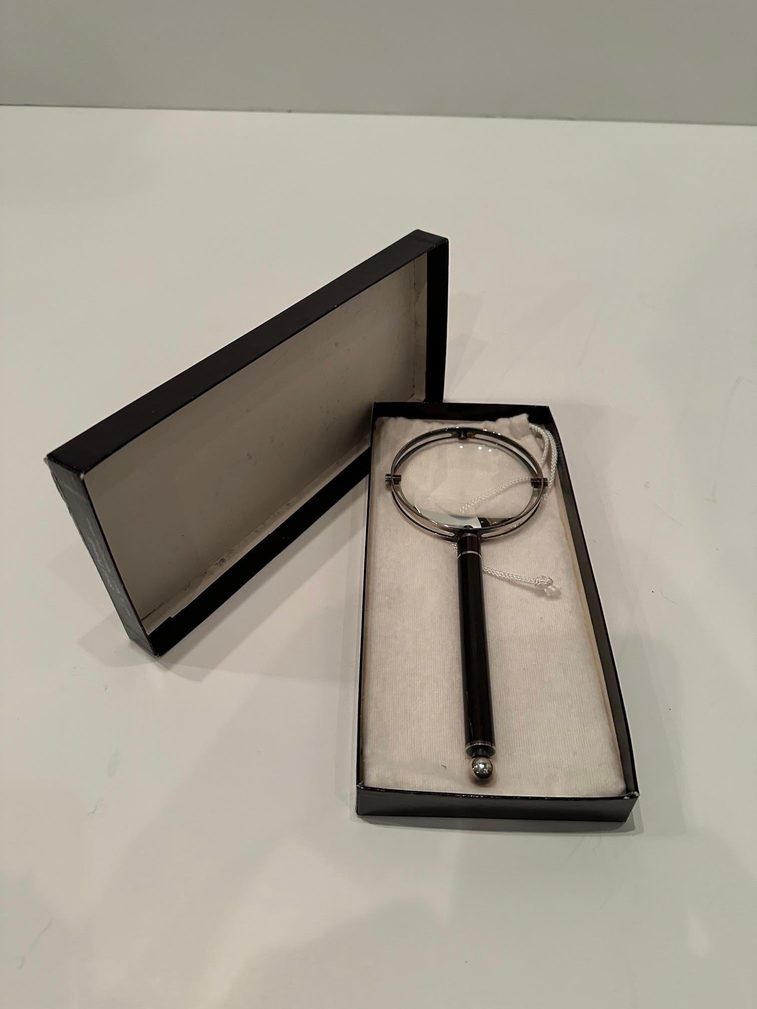 Splendida lente d'ingrandimento disegnata da Richard Meier per Swid Powerll, con manico in legno d'ebano, lastra d'argento e vetro, oltre a custodia e scatola originali.  