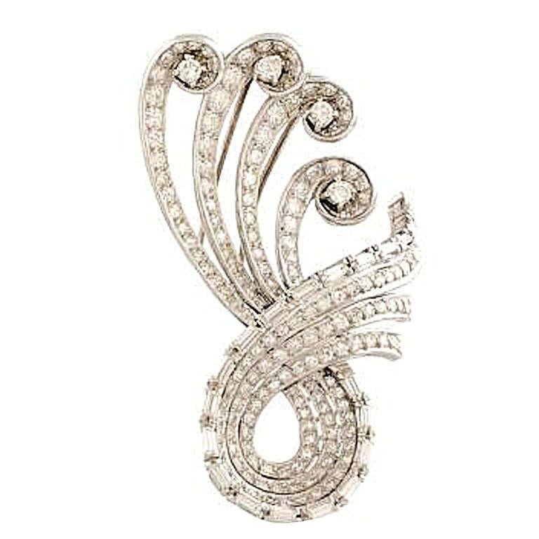 1950 Swirl brooch in platinum set with brilliant and baguette cut diamonds, four larger diamonds complete the scrolls, height 4.8 cm (30grs)