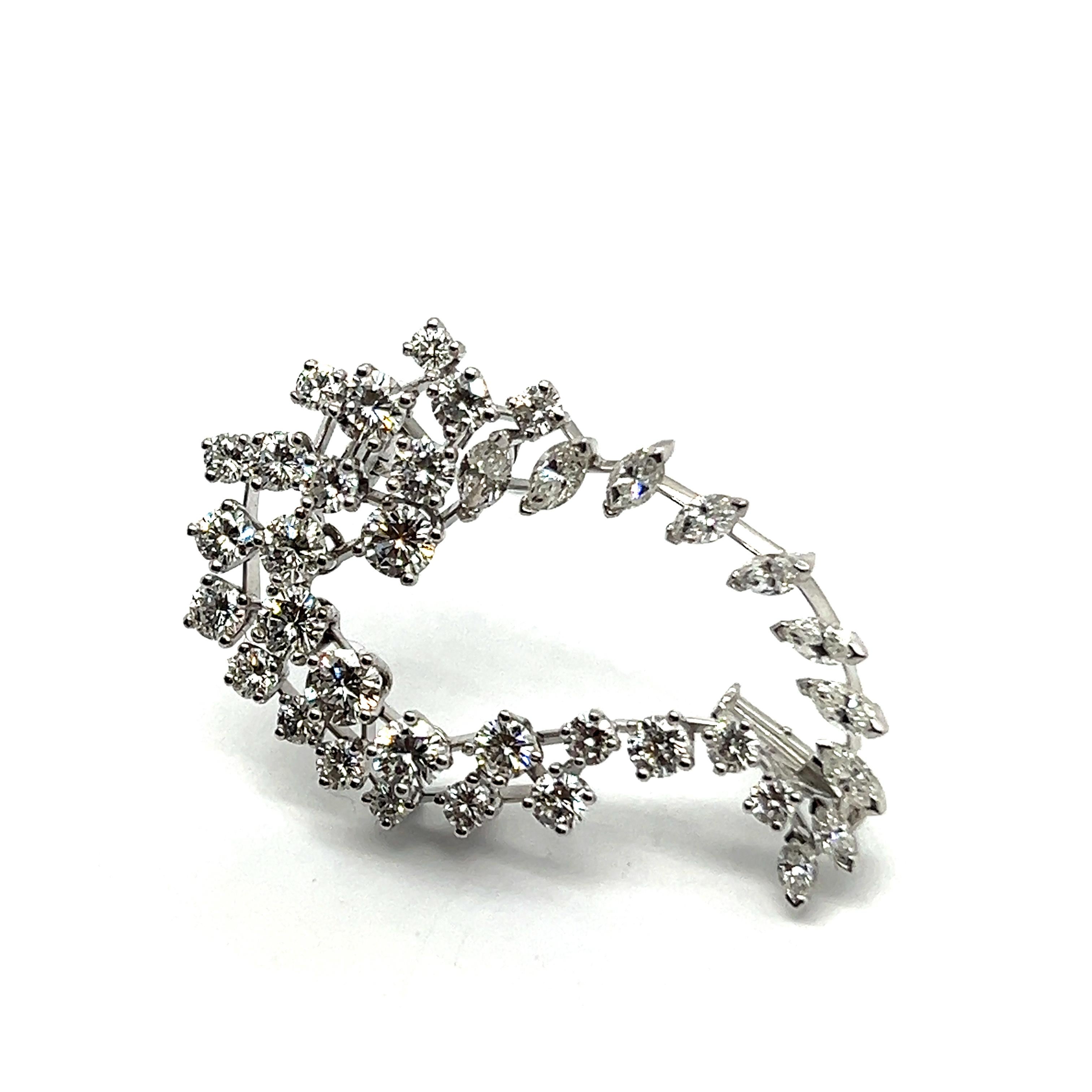 Elevate your elegance with our stunning diamond brooch in 18 Karat white gold. 

This exquisite piece features a graceful swirl design, adorned with 27 brilliant cut diamonds totaling 2.40 carats and 10 marquise cut diamonds totaling 1.10 carats.