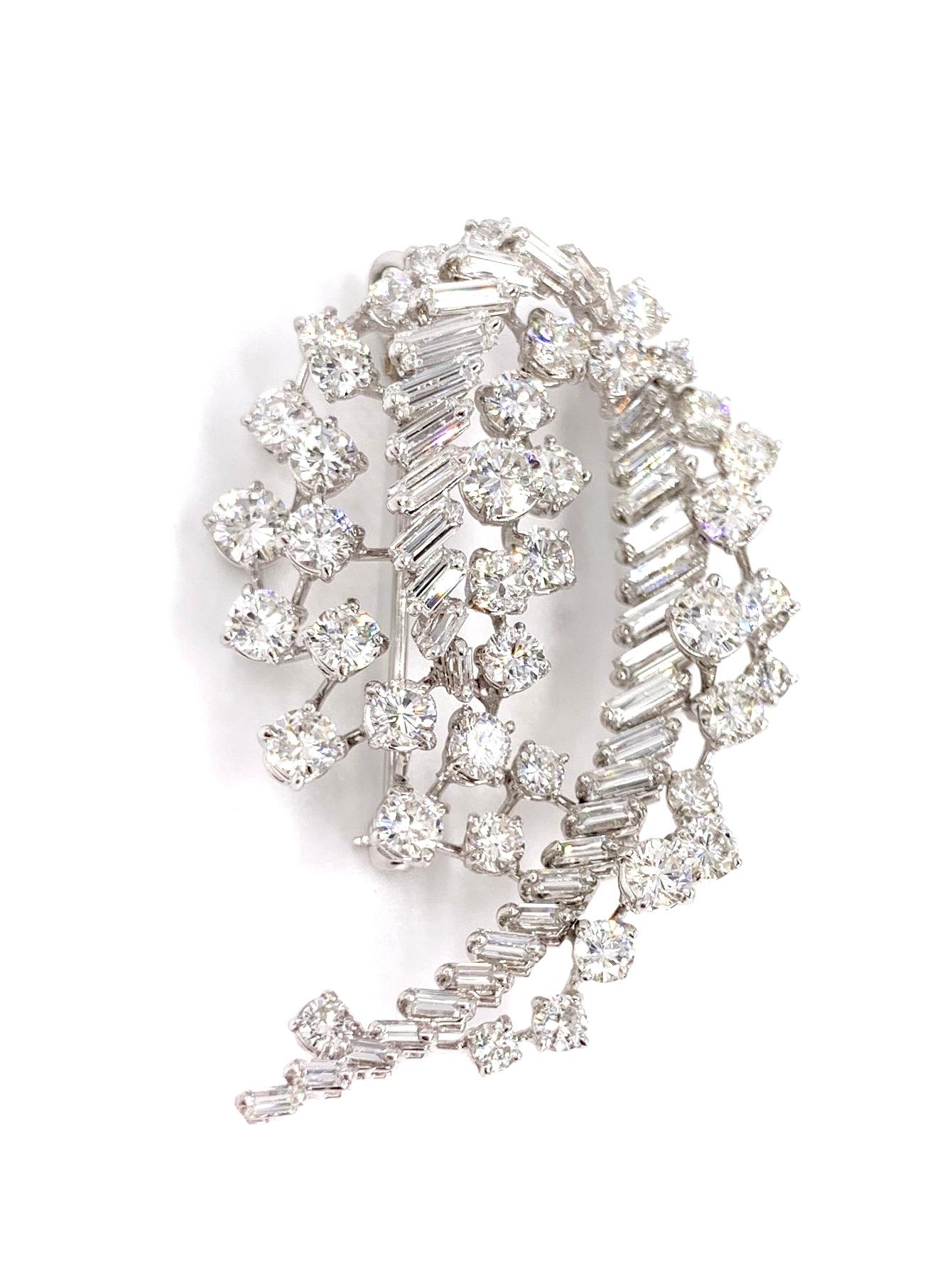 Designed in France, this exquisite 18 karat white gold diamond spray brooch doubles as a slide pendant. Swirl designed piece features approximately 6.50 carats of high quality round brilliant and baguette cut diamonds. Diamond quality is
