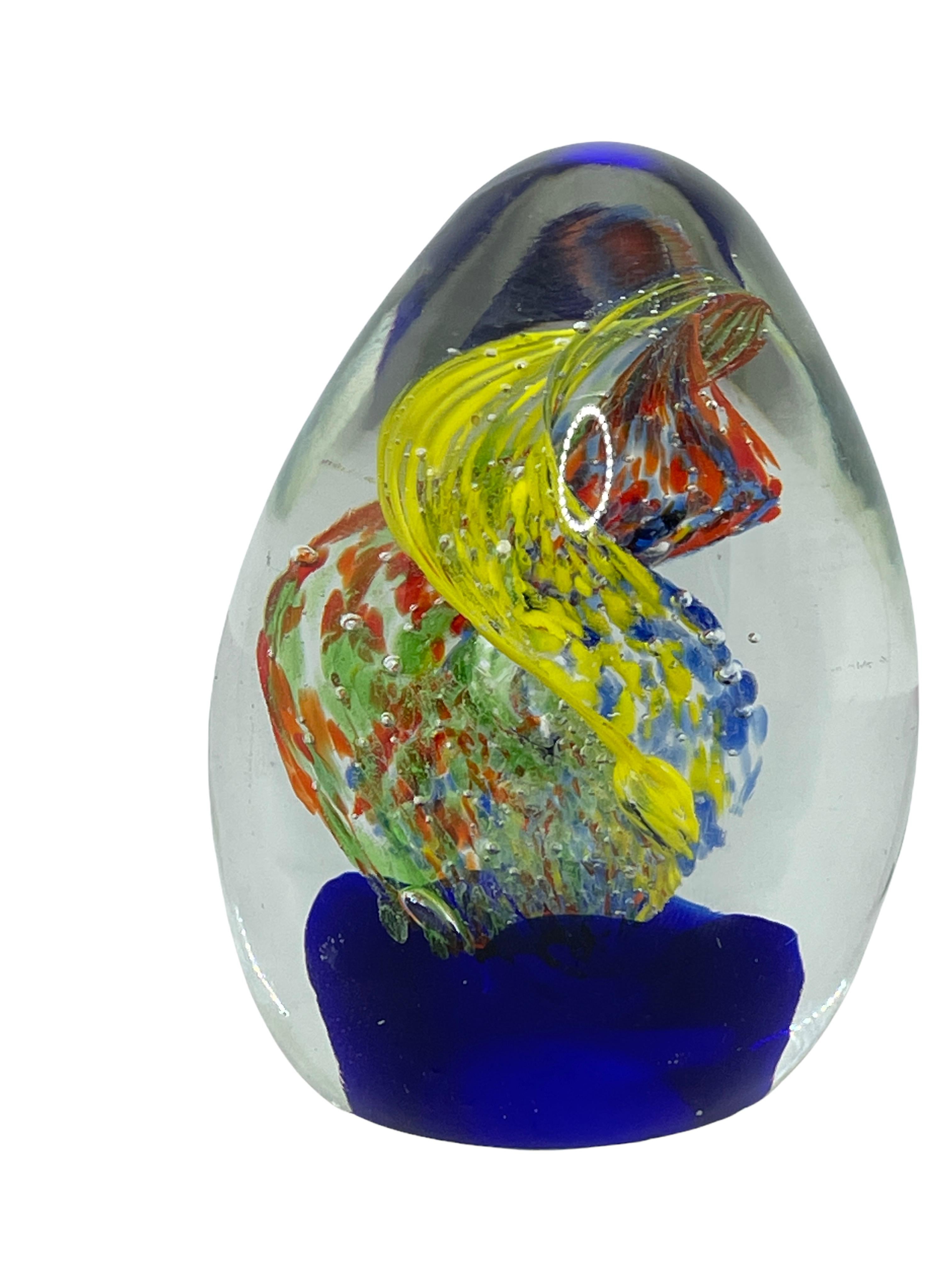 Beautiful Murano hand blown aquarium Italian art glass paper weight. Showing blue waves, with a swirl on top. Colors are a blue, yellow, red and clear. A beautiful nice addition to your desktop or as a center piece in every room.