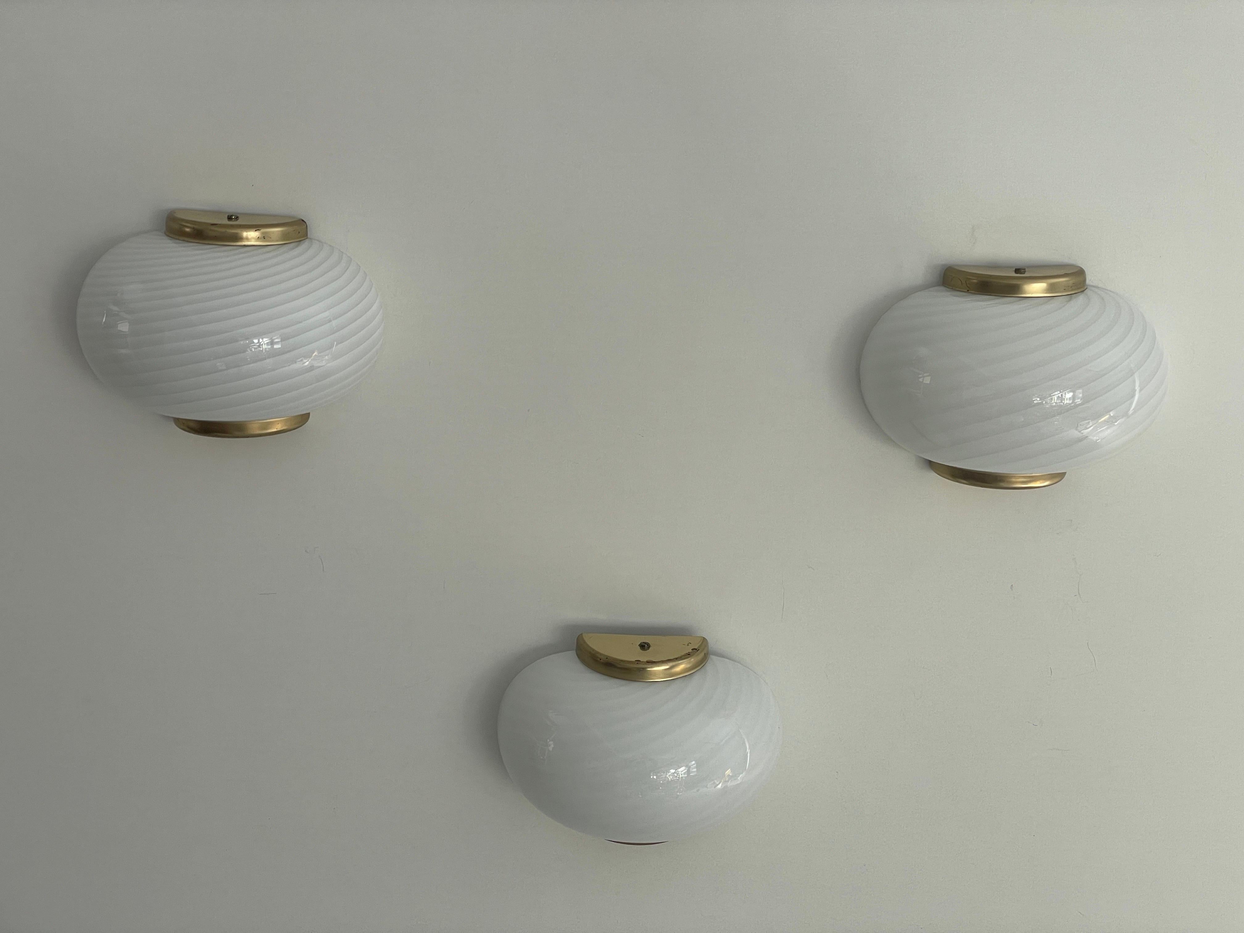 Swirl pattern Murano Glass and Brass Set of 3 Sconces by Beatrix, 1970s, Italy

Very elegant and minimalist wall lamps.
Lamp is in very good condition.

These lamps works with E14 standard light bulbs. 
Wired and suitable to use in all countries.
