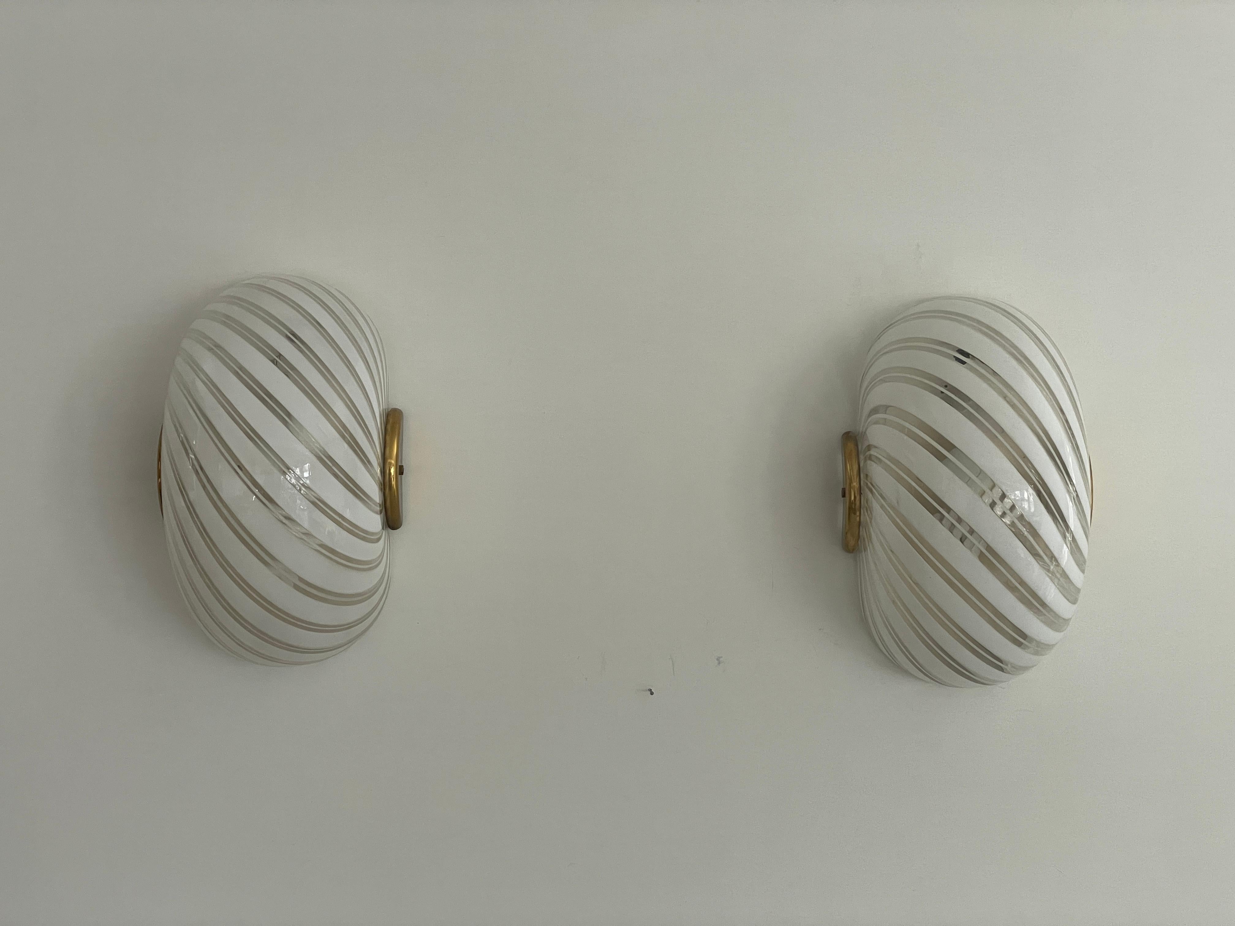 Coppia di appliques in vetro di Murano con motivo a vortice di F. Fabbian, anni '70, Italia

Lampade da parete molto eleganti e minimaliste.
La lampada è in ottime condizioni.

Queste lampade funzionano con lampadine standard E27. 
Cablato e adatto
