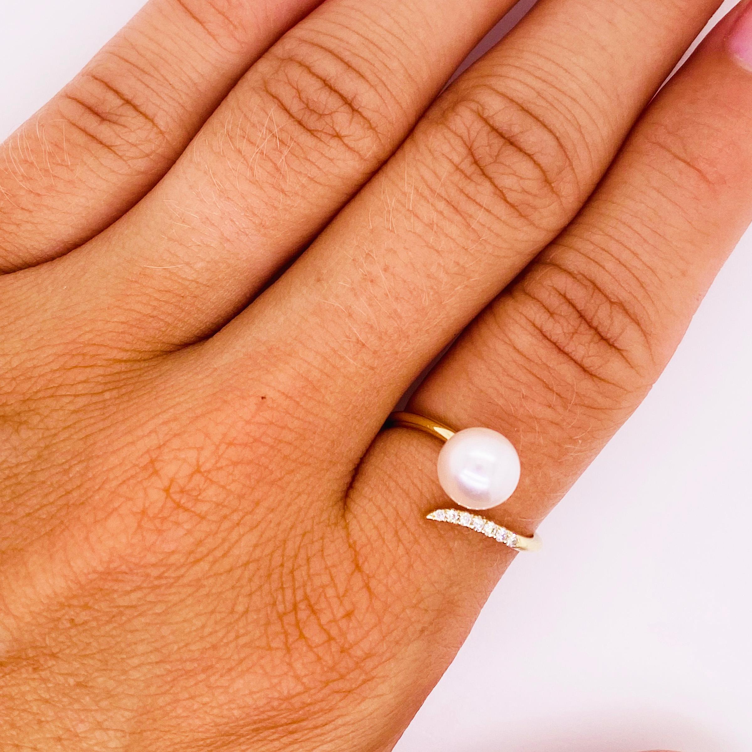 This authentic pearl and diamond ring was designed so that it swirls on the finger.  One side of the negative space ring has seven full cut diamonds, the other side has a 7 millimeter pearl.  The pearl is a genuine, cultured, Japanese, saltwater