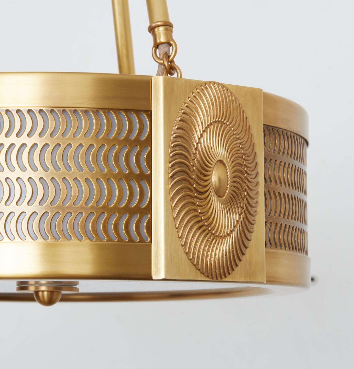 A new, contemporary David Duncan design. A brass pendant suspended from brass canopy and three rods, with comma-shaped cutouts emitting light through opal plexi diffusers on the sides. The frame is divided into three sections, with over-scaled oval,