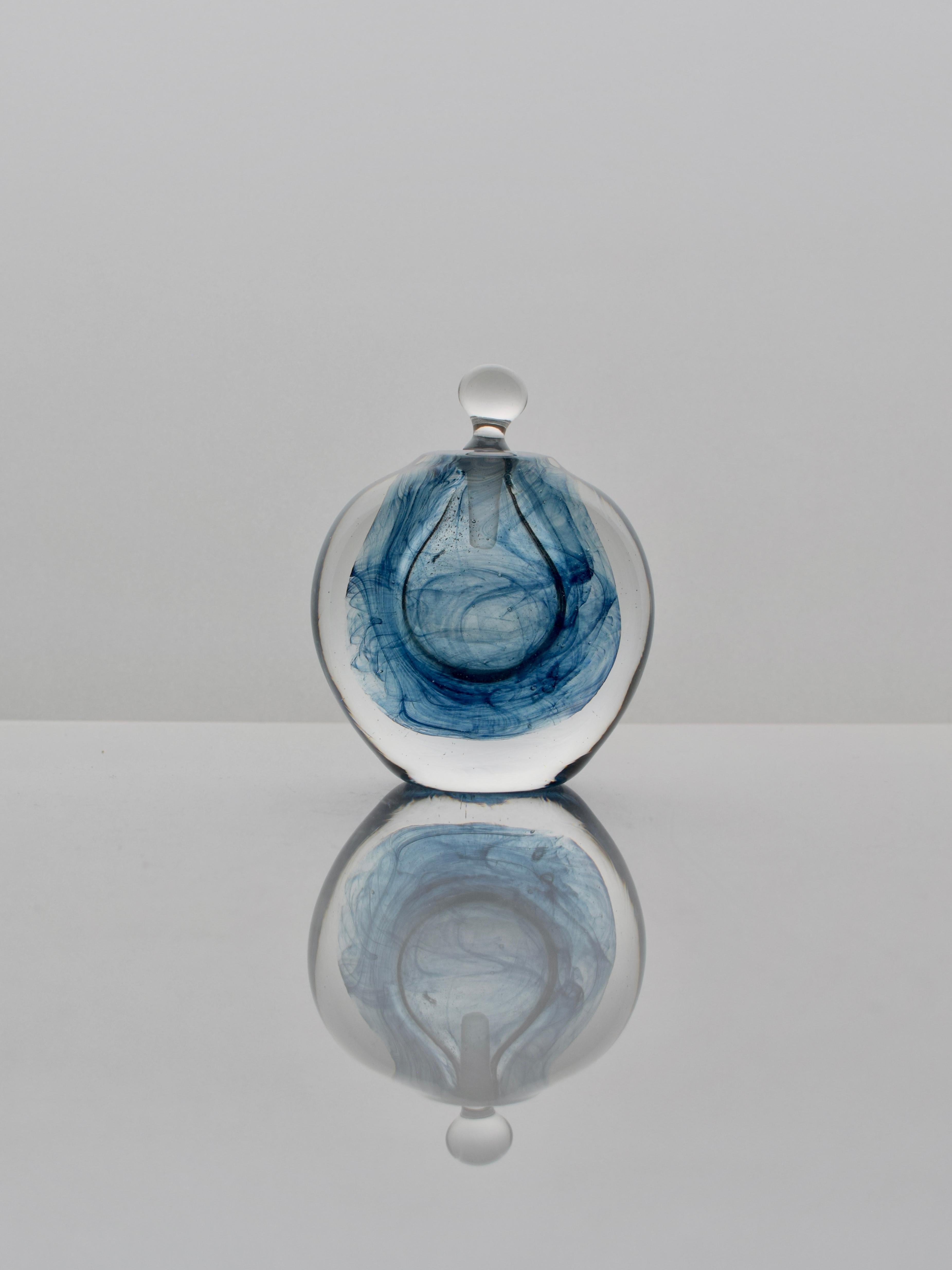 Il colore vorticoso all'interno della bottiglia viene creato immergendo il vetro fuso all'estremità del cannello in scaglie di vetro colorate. Il vetro colorato viene poi stirato e ruotato in modo controllato per produrre un effetto interno unico.