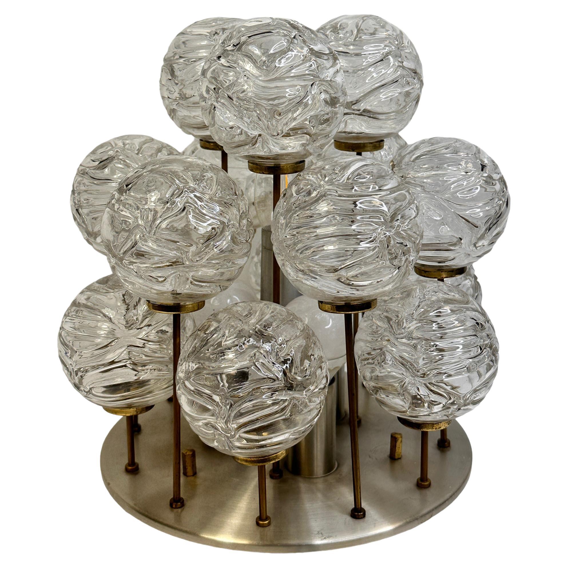 Swirled glass ball flush mount fixture by Doria Leuchten, Germany. The handblown glass ball elements are attached to brass rods in varying lengths that when illuminated by the single light source makes a beautiful light. The Fixture requires four