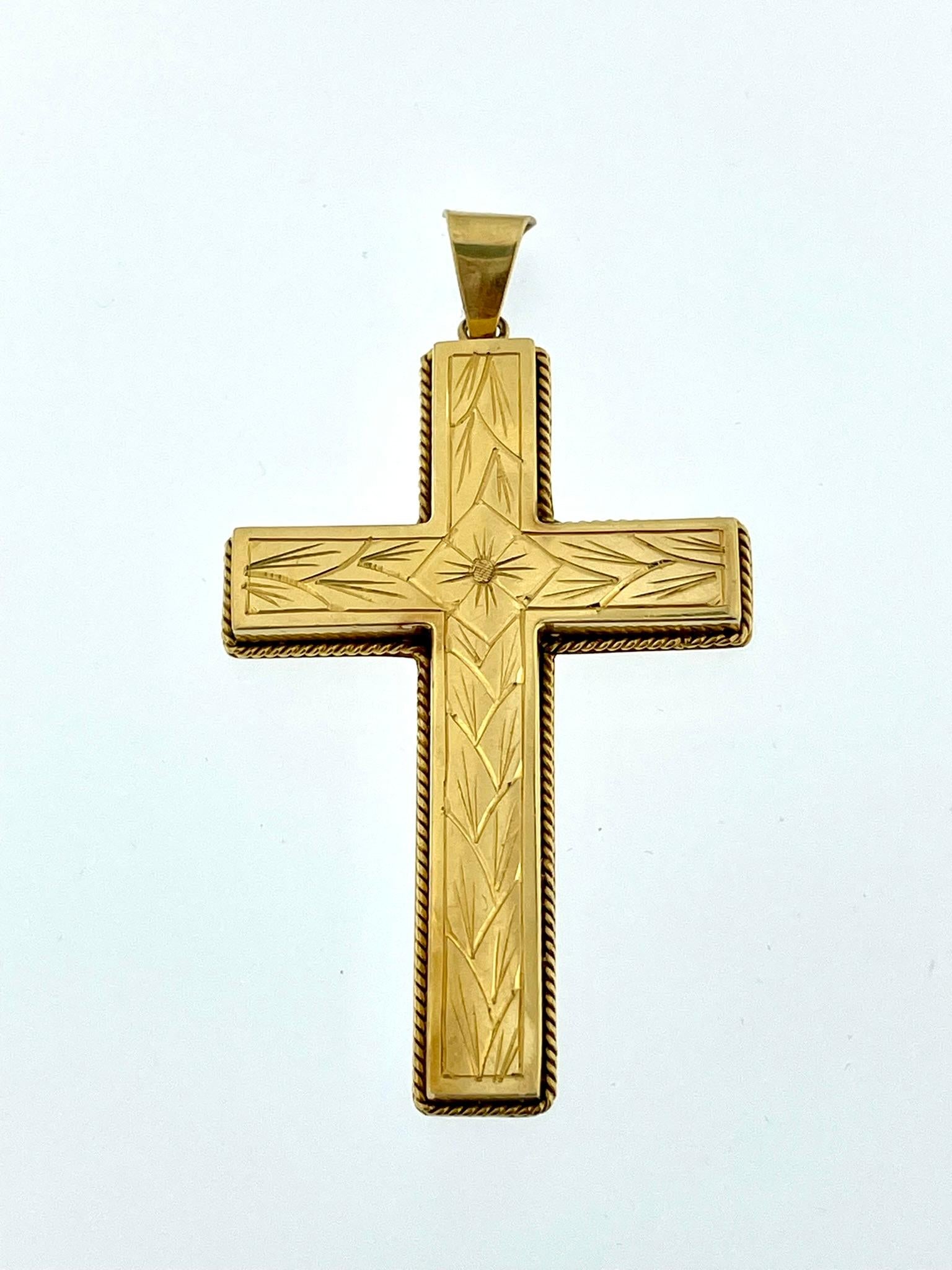 The Swiss 18kt Yellow Gold Cross with Flower Patterns is a meticulously crafted and exquisite piece of jewelry. It is a stunning representation of artisanal craftsmanship, featuring intricate hand-carved details and a unique wire technique. The