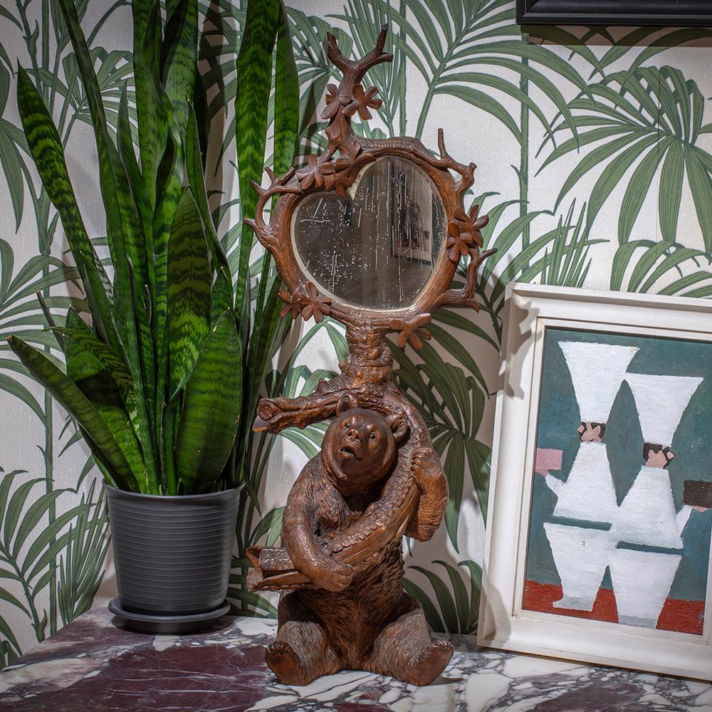 De notre collection Black Forest, nous avons le plaisir de vous présenter ce miroir de table en forme d'ours de la forêt noire, superbement sculpté. Le Black Forest Mirror représente un ours assis, plein d'expression, qui saisit une grosse branche