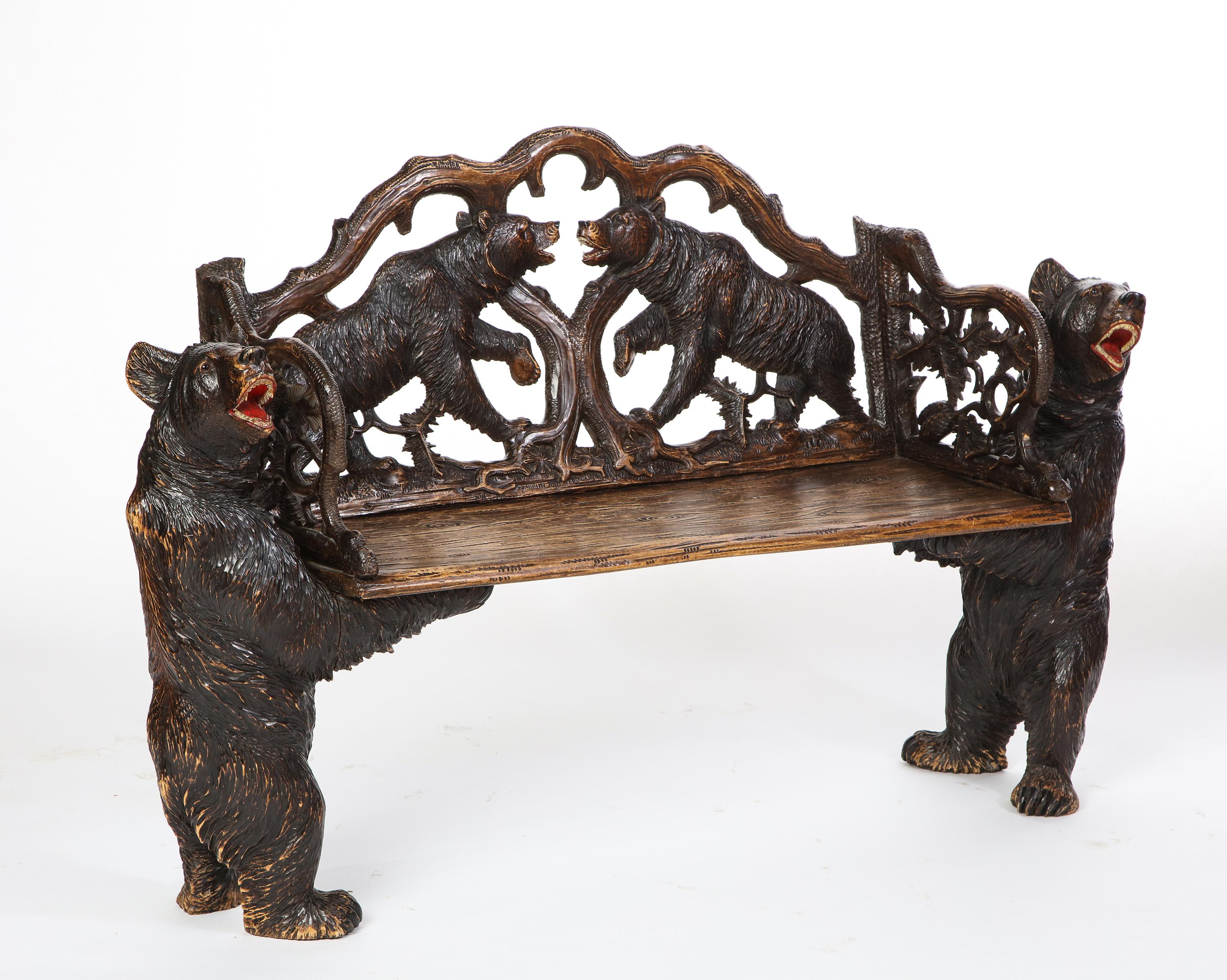 A Swiss ‘Black Forest’ carved hall bench. This carved wooden bench is perfectly suited for a mountain chalet. Featuring two growling bears with glass set eyes supporting an intricately carved seat. This bench is a lovely example of ‘black forest’