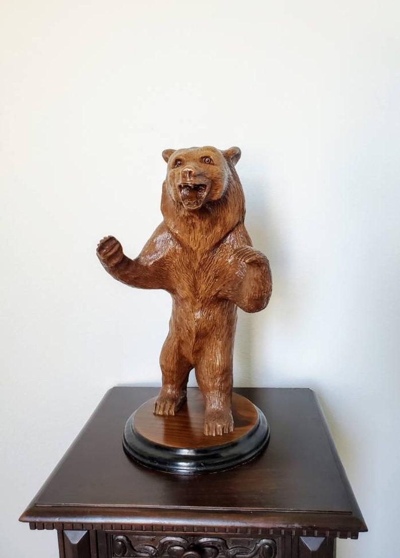 A fine quality antique Swiss Black Forest ware, born in the early 20th century, exquisitely hand carved, lacquered wooden bear figure. The exceptionally executed naturalistic sculpture appears to capture the bear in motion, standing on two feet,