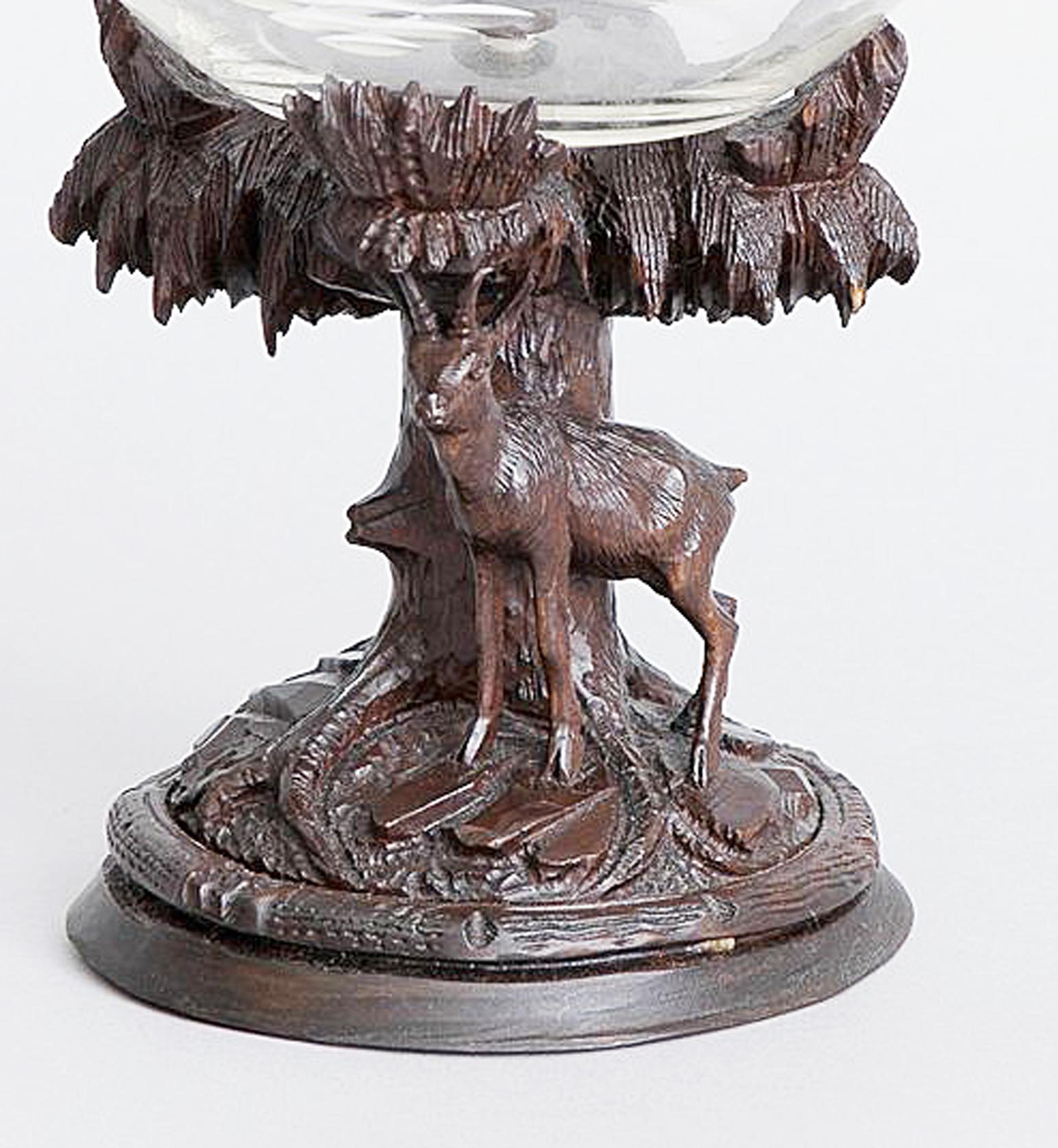Swiss Black Forest carved linden wood and cut glass compote,
Marked Gewidmet Von Turnverein/ Meiringen,
circa 1890-1900.

The Black Forest compote is in two sections- a glass bowl secured with a shaped linden wood button CAP and a linden wood