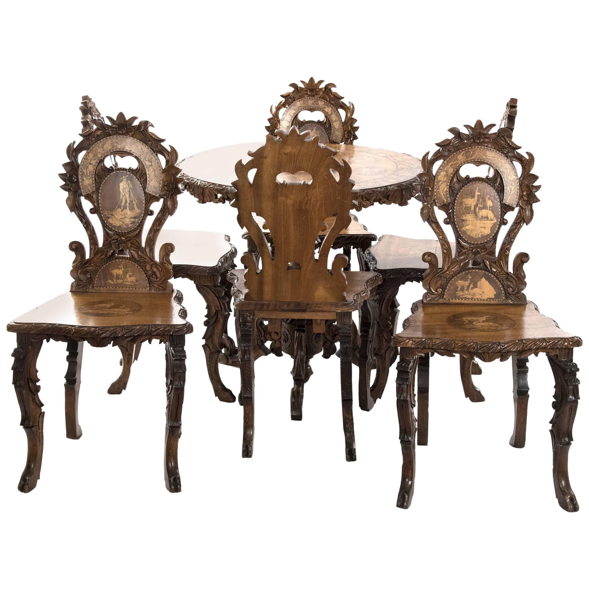 Swiss Black Forest Carved Marquetry Tilt-Top Table and Six Chairs