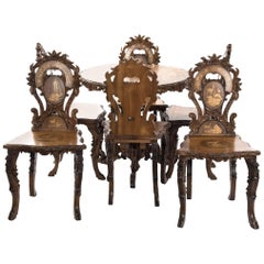 Swiss Black Forest Carved Marquetry Tilt-Top Table and Six Chairs