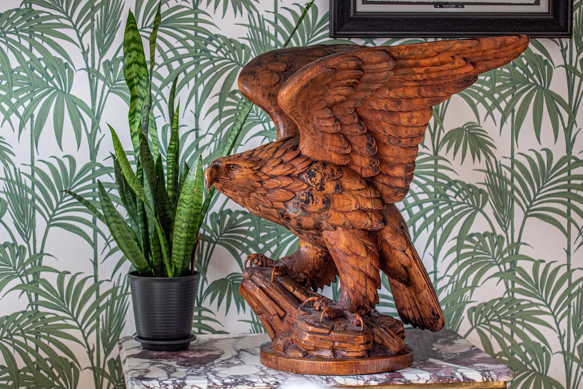 Belle sculpture suisse d'aigle de la Forêt-Noire de taille importante. L'aigle est magnifiquement sculpté avec des détails exceptionnels, perché sur un affleurement rocheux avec une base arrondie. L'aigle aux serres menaçantes s'agrippe au rocher