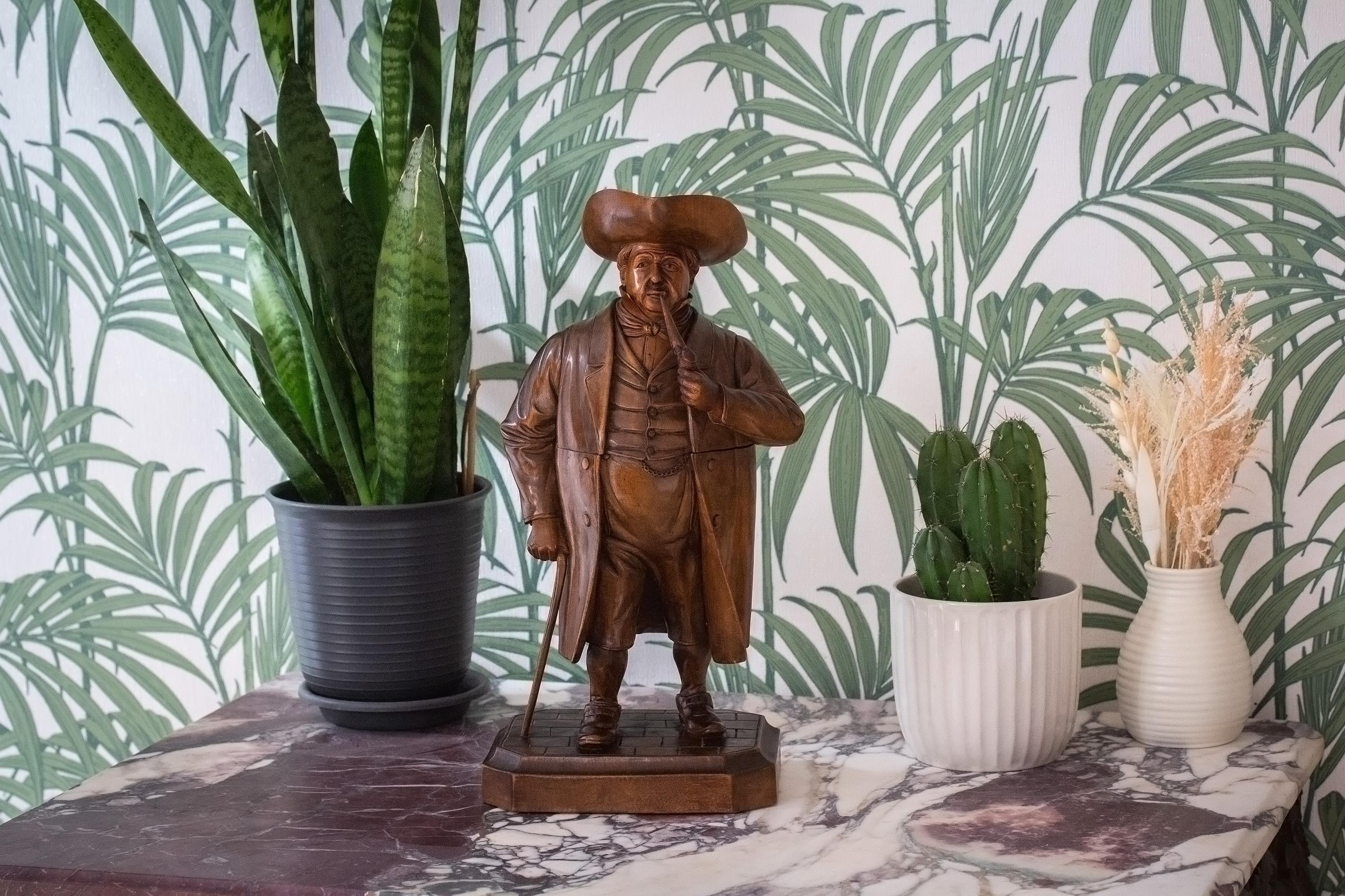 Fine and rare Swiss Black Forest carving of a Nobleman shaped as a tobacco jar. The rotund man stands proud with pipe in hand leaning on a walking cane dressed in high status attire. The carving is of exceptional detail showing the quality of the