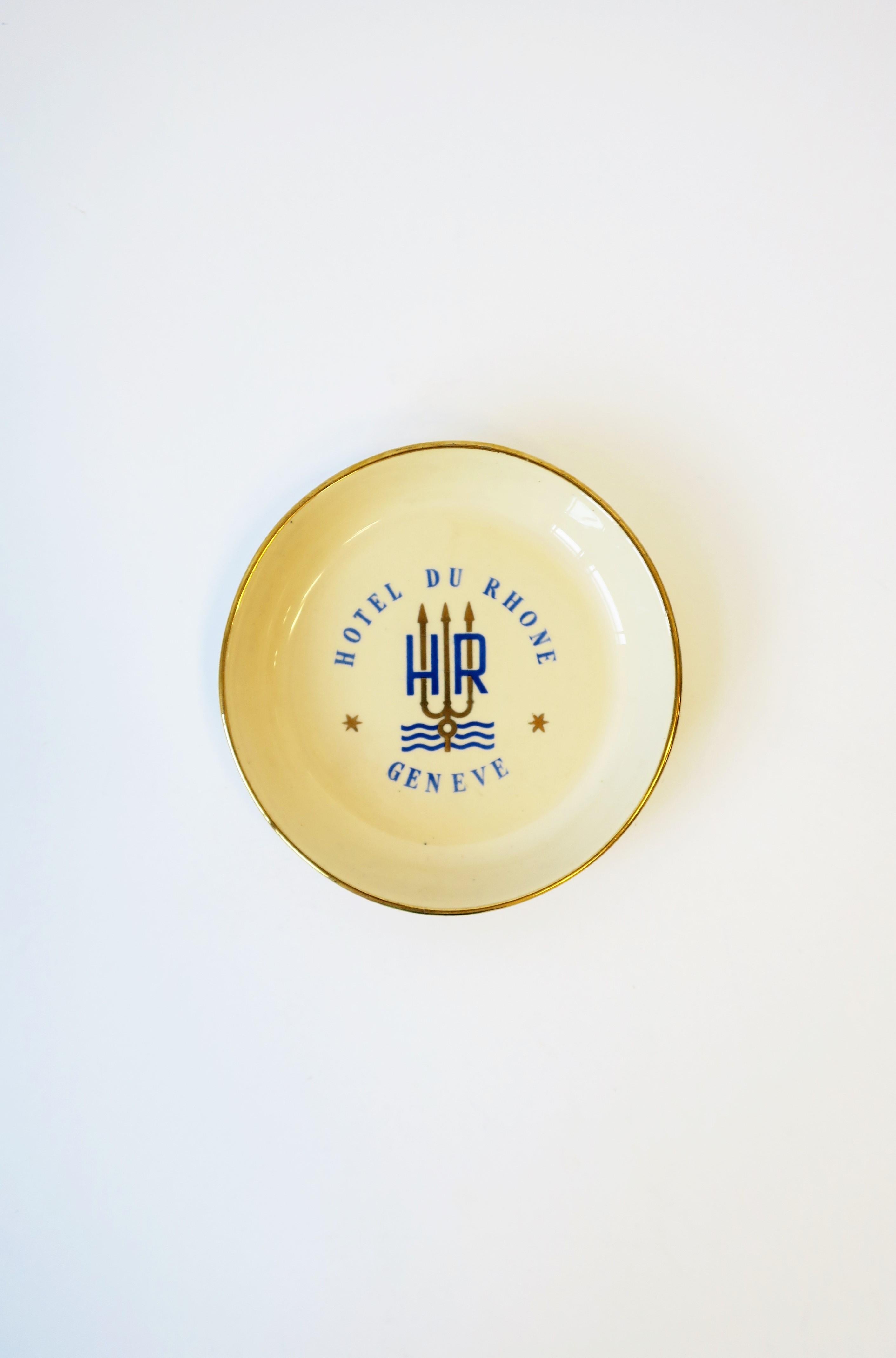 A small round European blue and gold porcelain jewelry dish from Swiss luxury hotel brand 